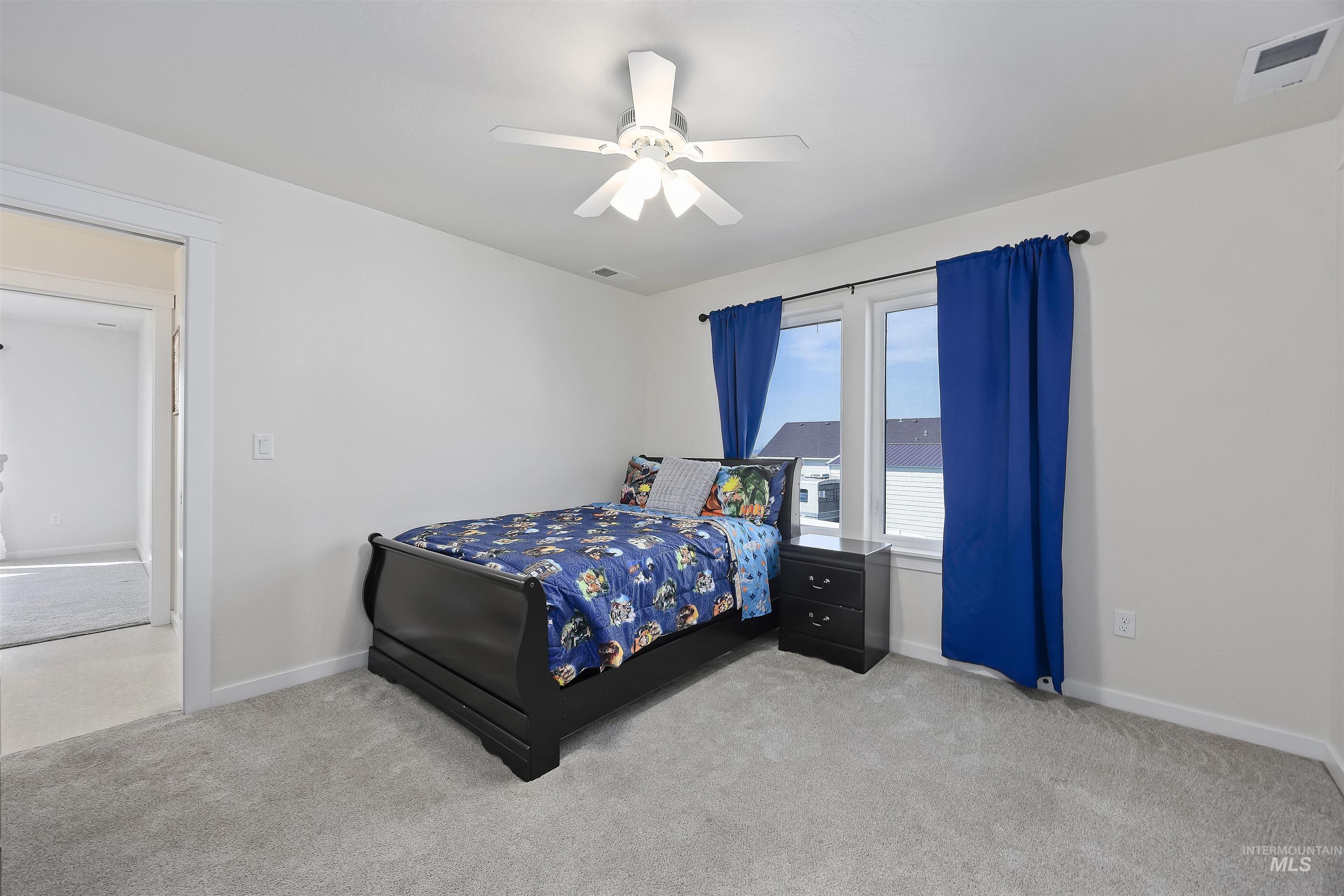 Bedroom featuring light carpet and a ceiling fan