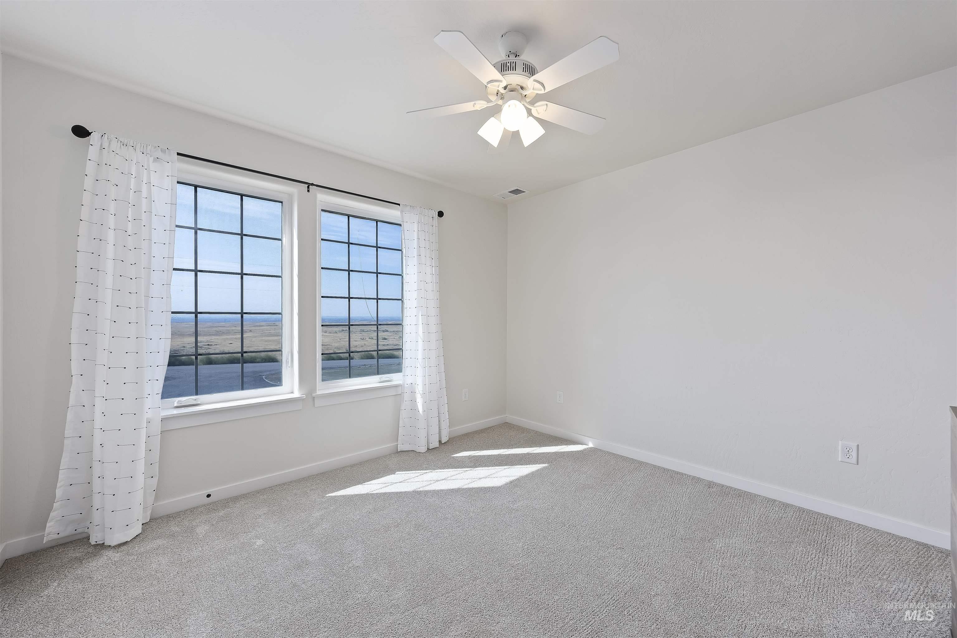 Empty room featuring carpet and ceiling fan