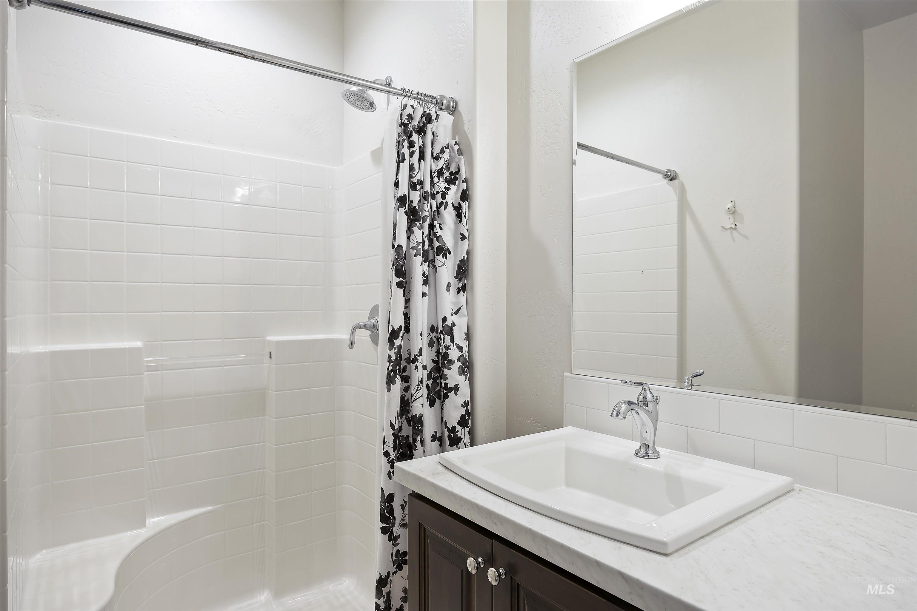 Bathroom with a shower stall and vanity