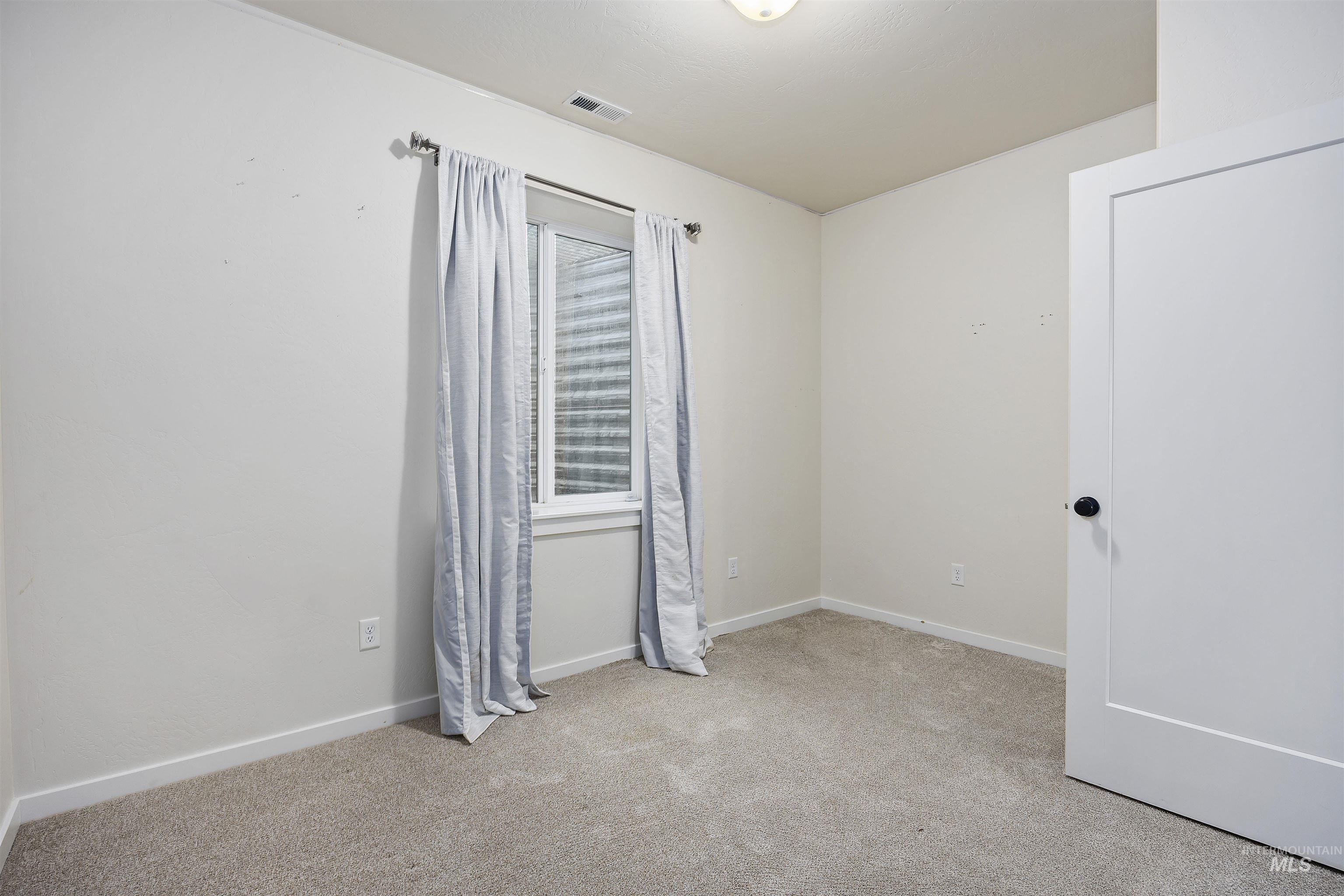 Unfurnished bedroom featuring light colored carpet and baseboards