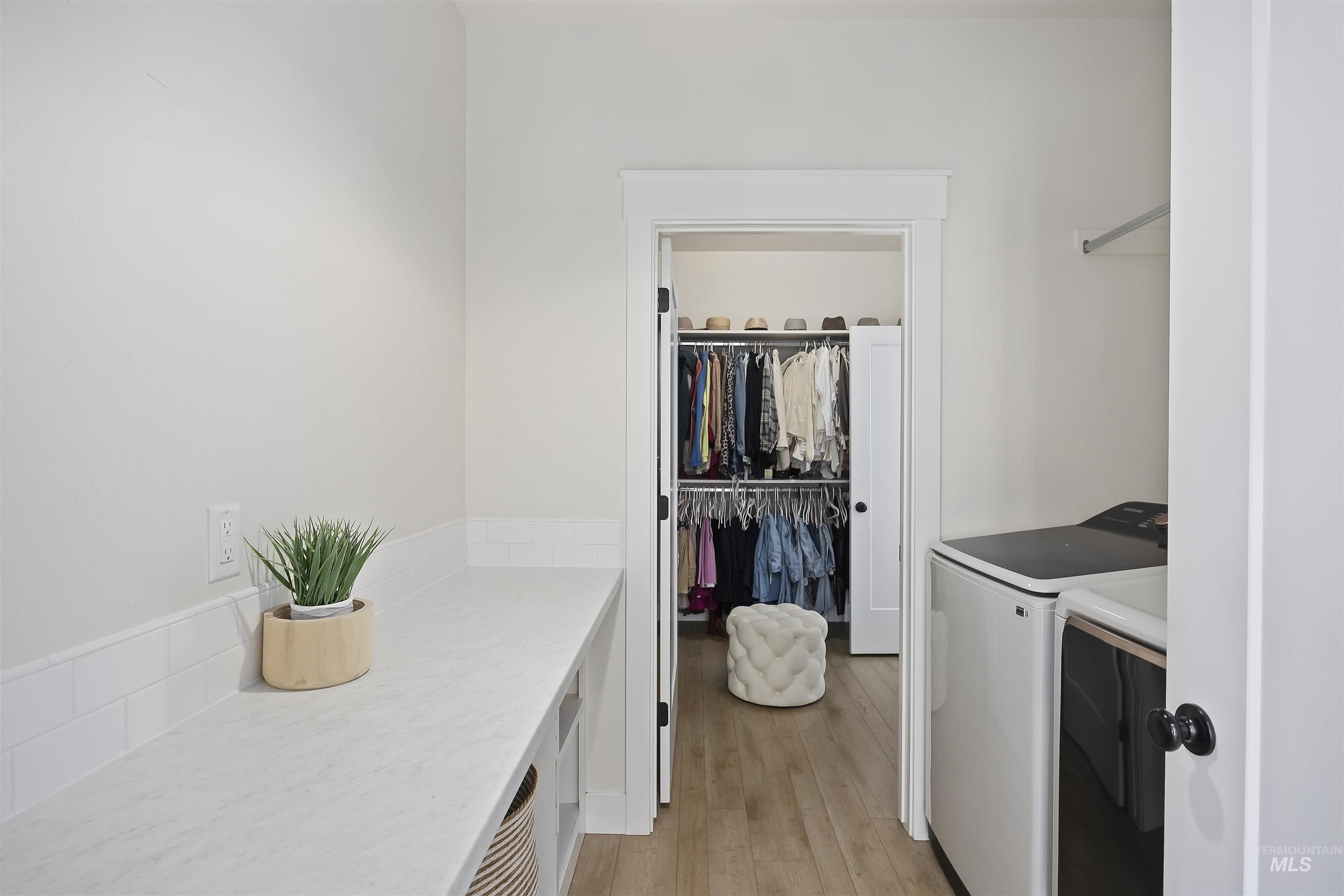 Laundry room featuring light wood-type flooring and separate washer and dryer