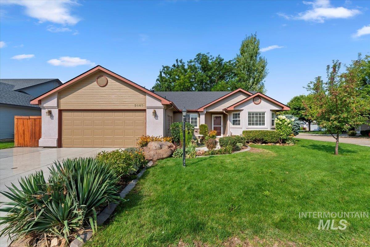 Ranch-style house with concrete driveway, a garage, and a front lawn