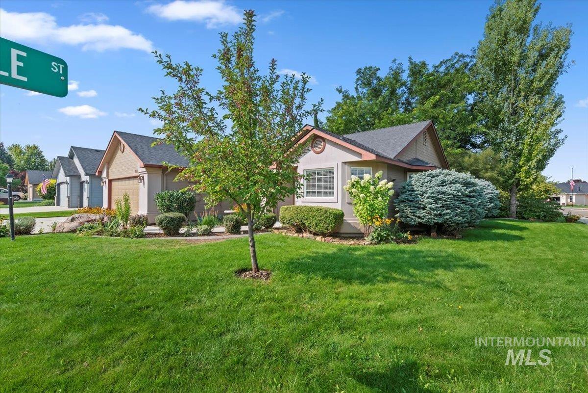 View of front of property featuring a front yard and a garage
