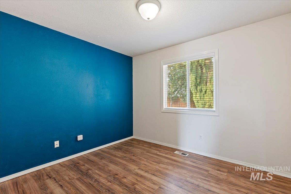 Unfurnished room featuring wood finished floors and baseboards