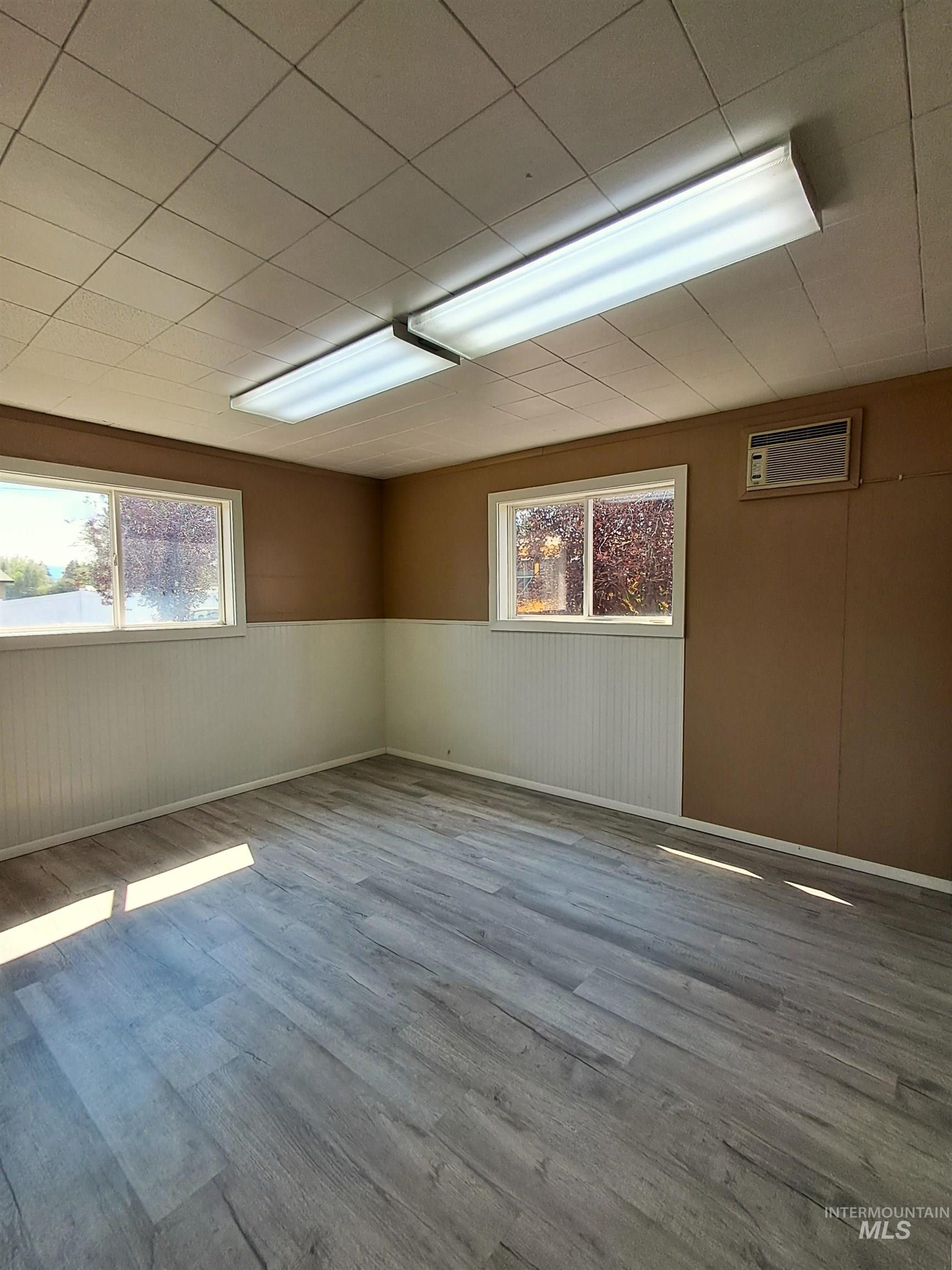 Below grade area featuring wood finished floors and a wainscoted wall