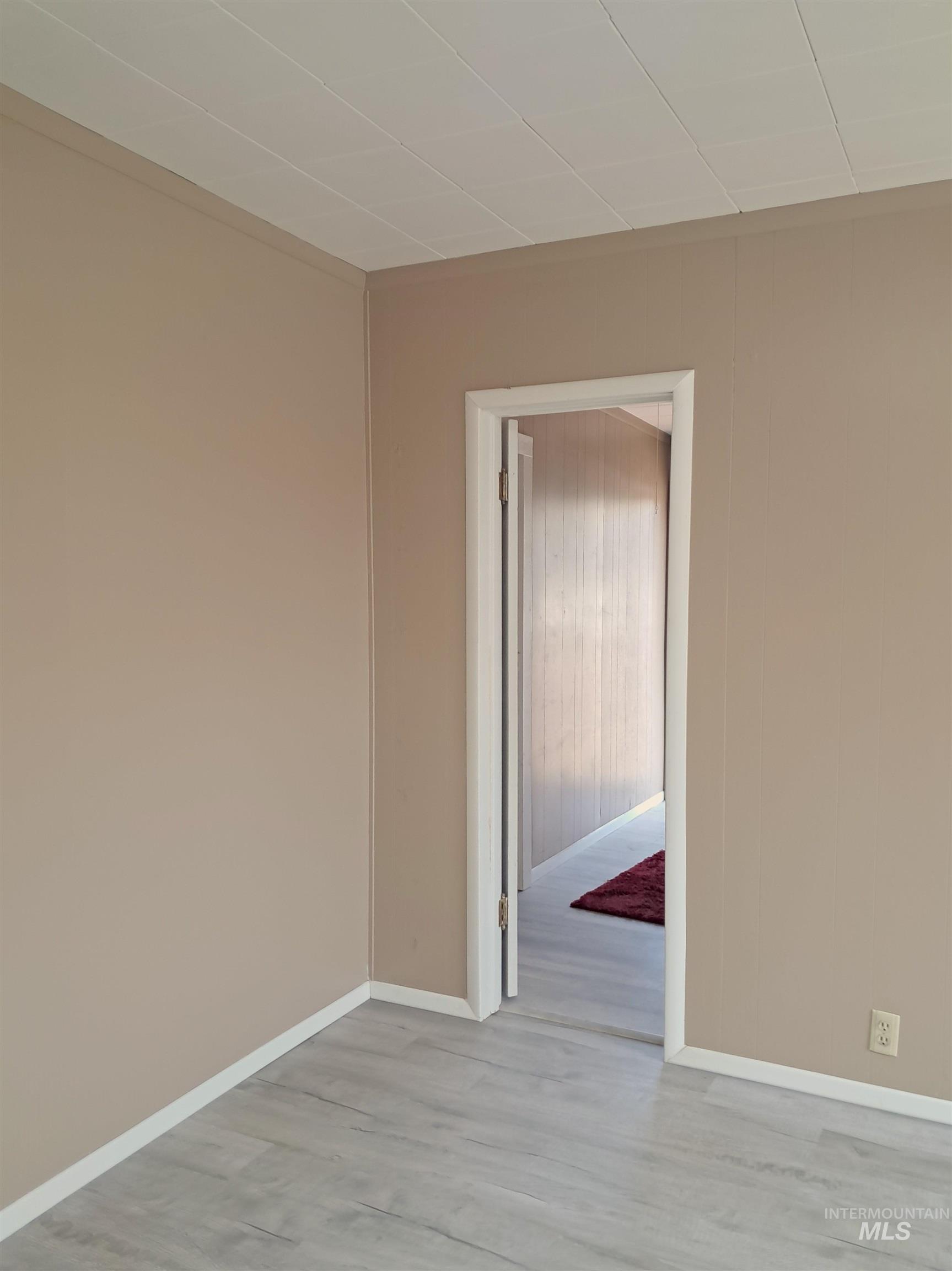Unfurnished room featuring light wood-type flooring and baseboards
