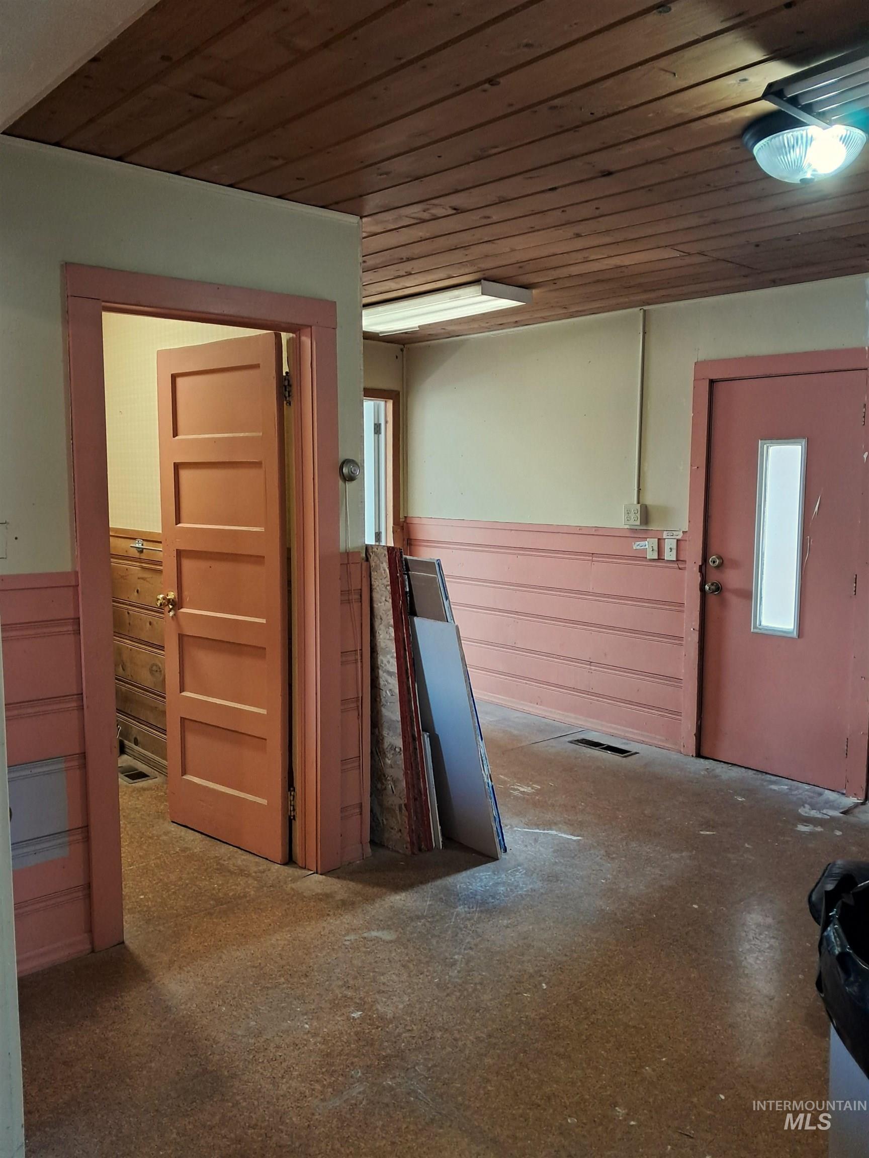 Hall featuring a wainscoted wall, wood ceiling, and wood walls