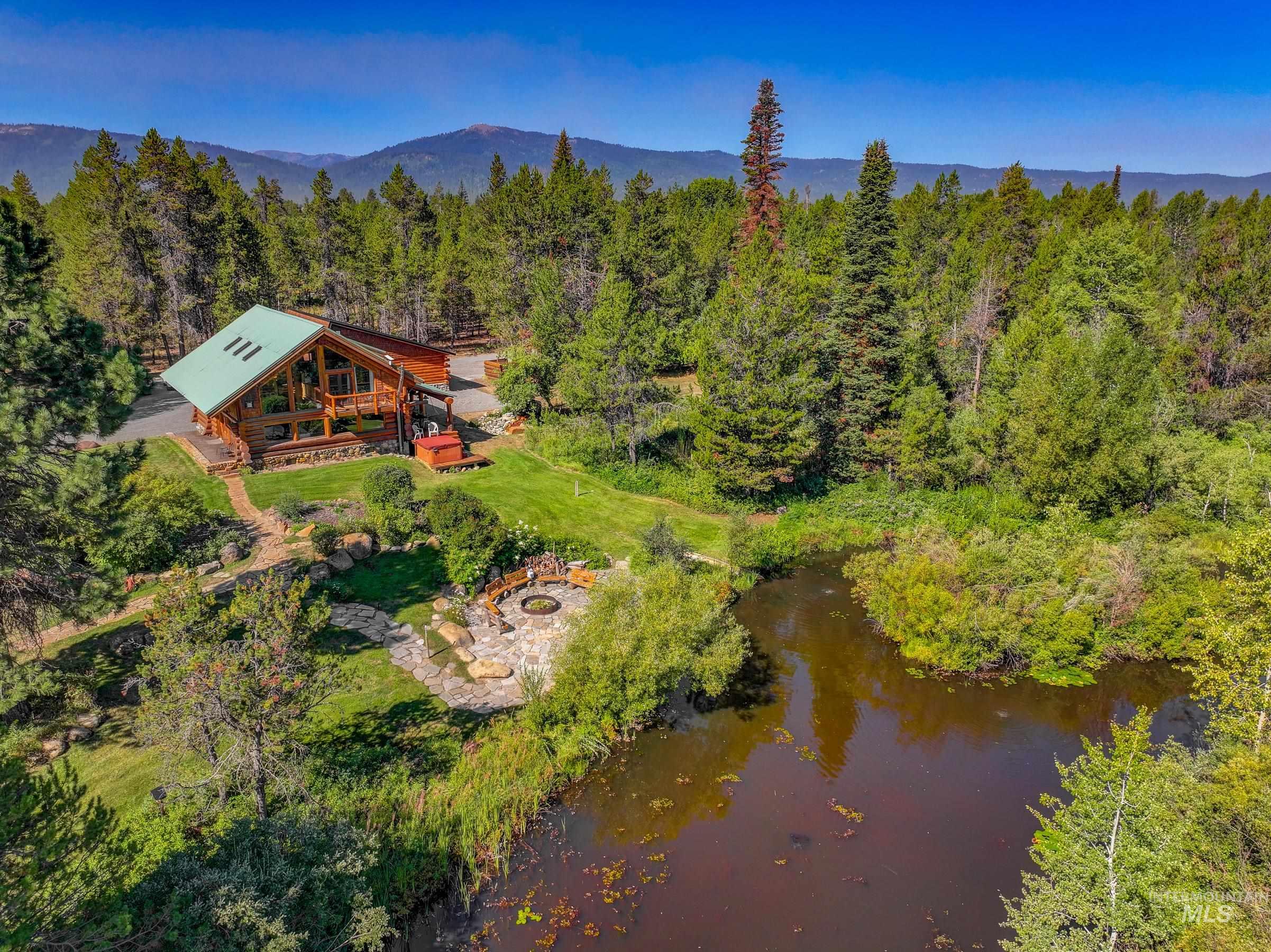 View from above of property with a large body of water and a forest