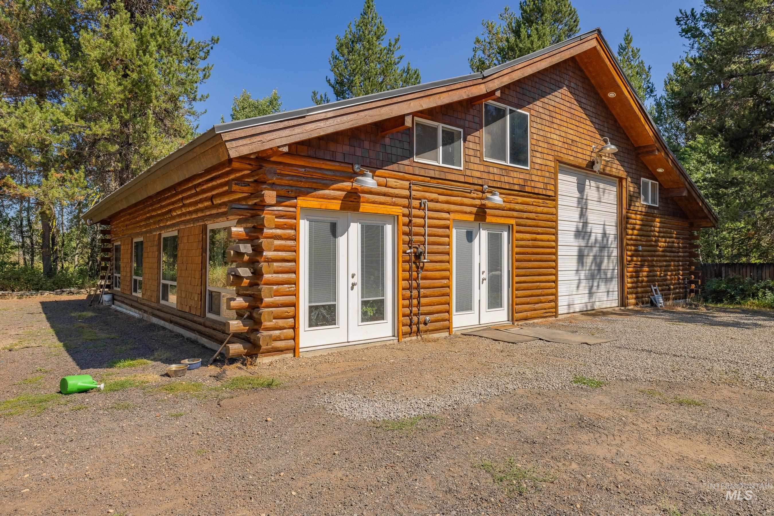 Back of house featuring log siding and french doors