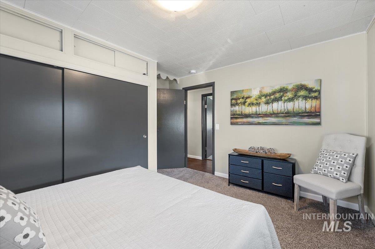 Carpeted bedroom with a closet and baseboards