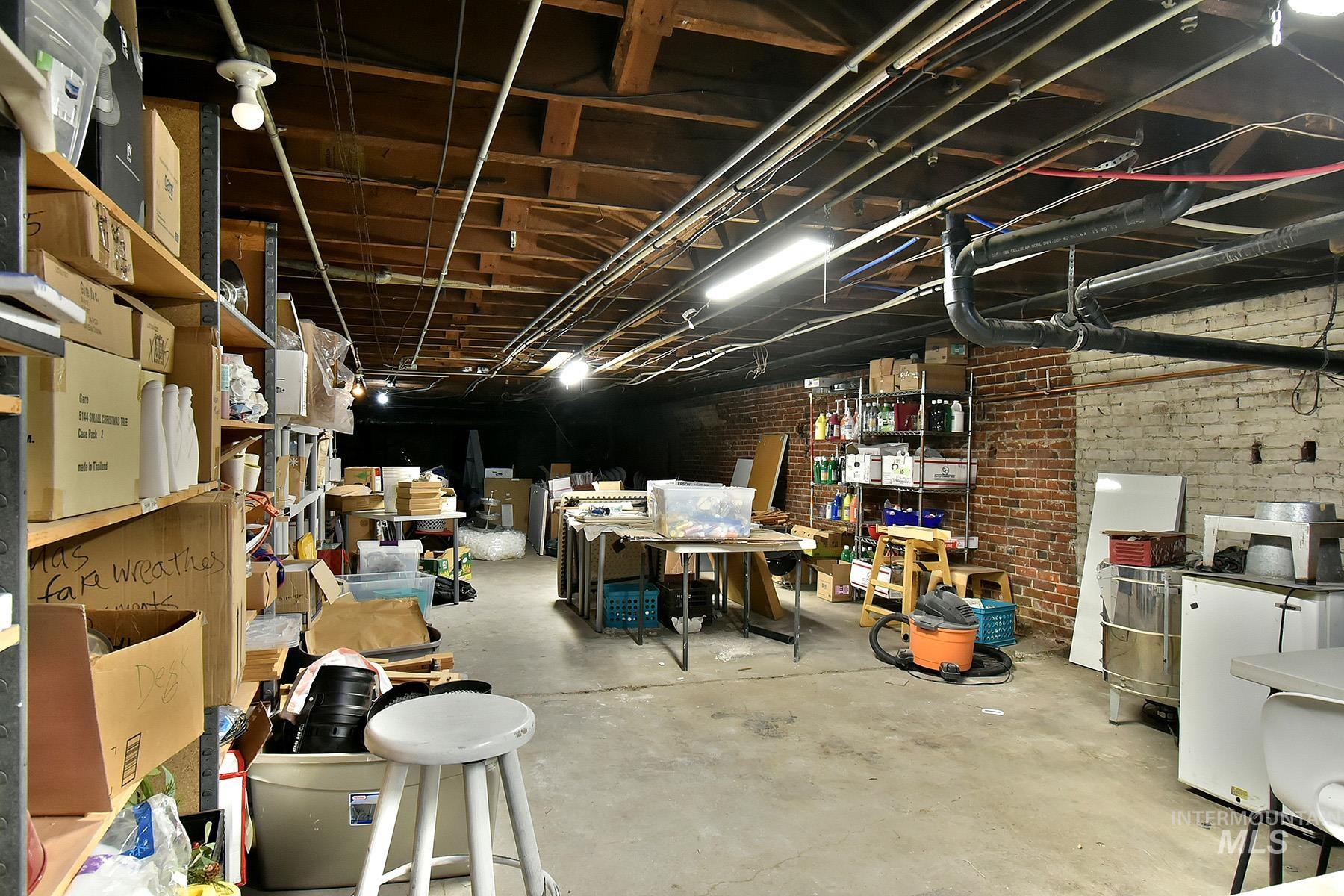 Basement featuring brick wall and white refrigerator