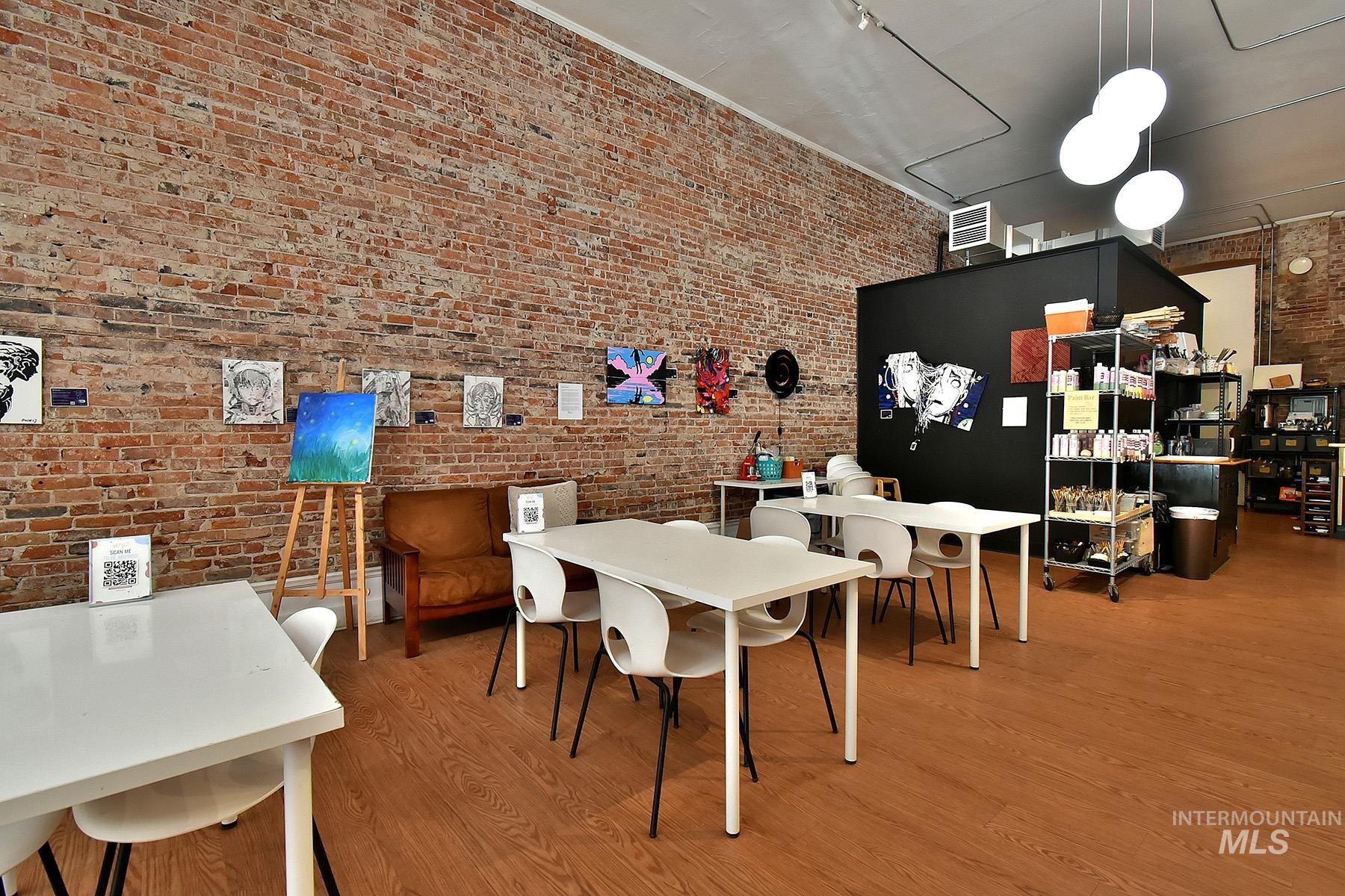 Dining space featuring brick wall and light wood finished floors
