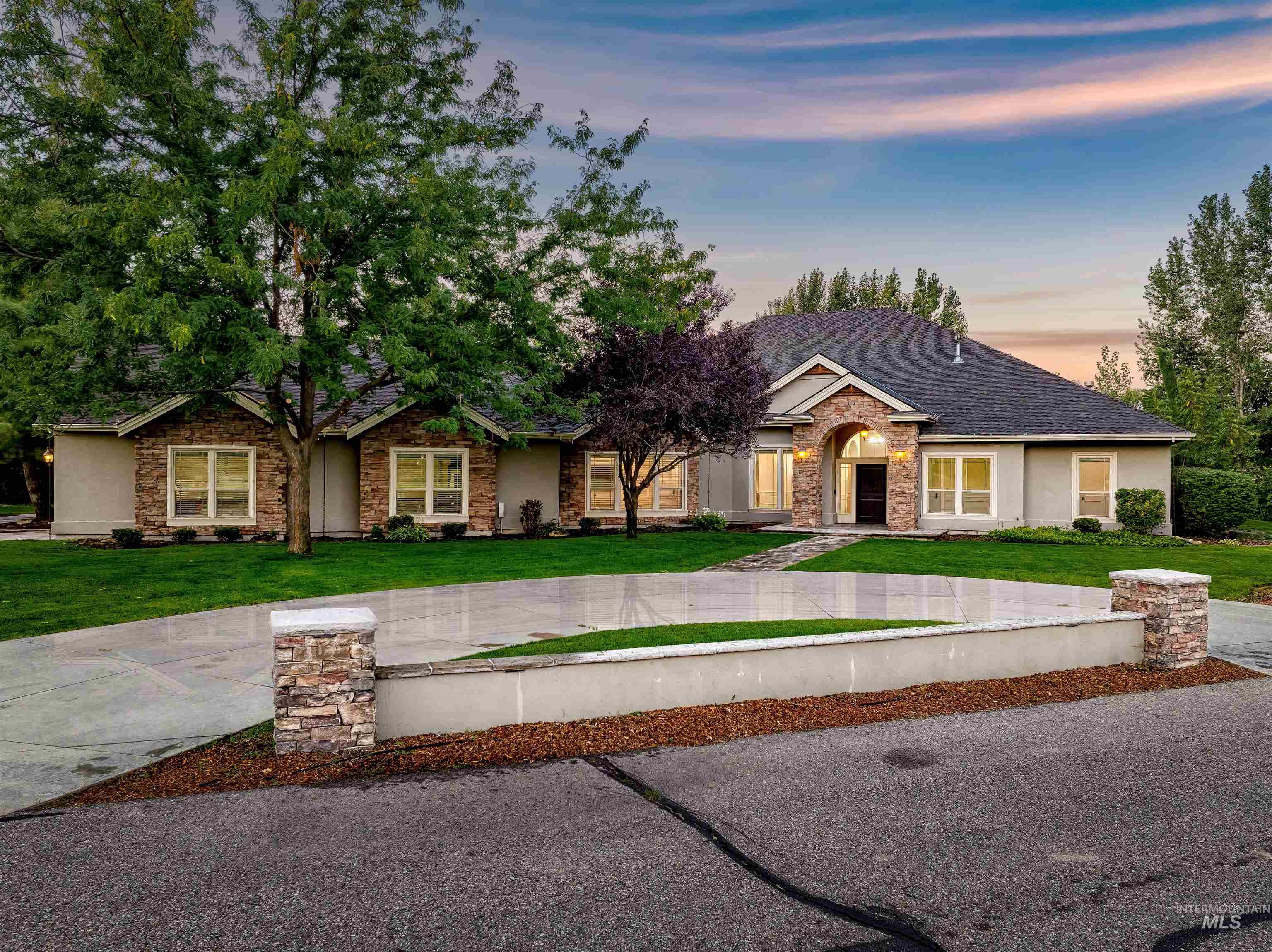 Ranch-style home featuring a yard, stone siding, and stucco siding