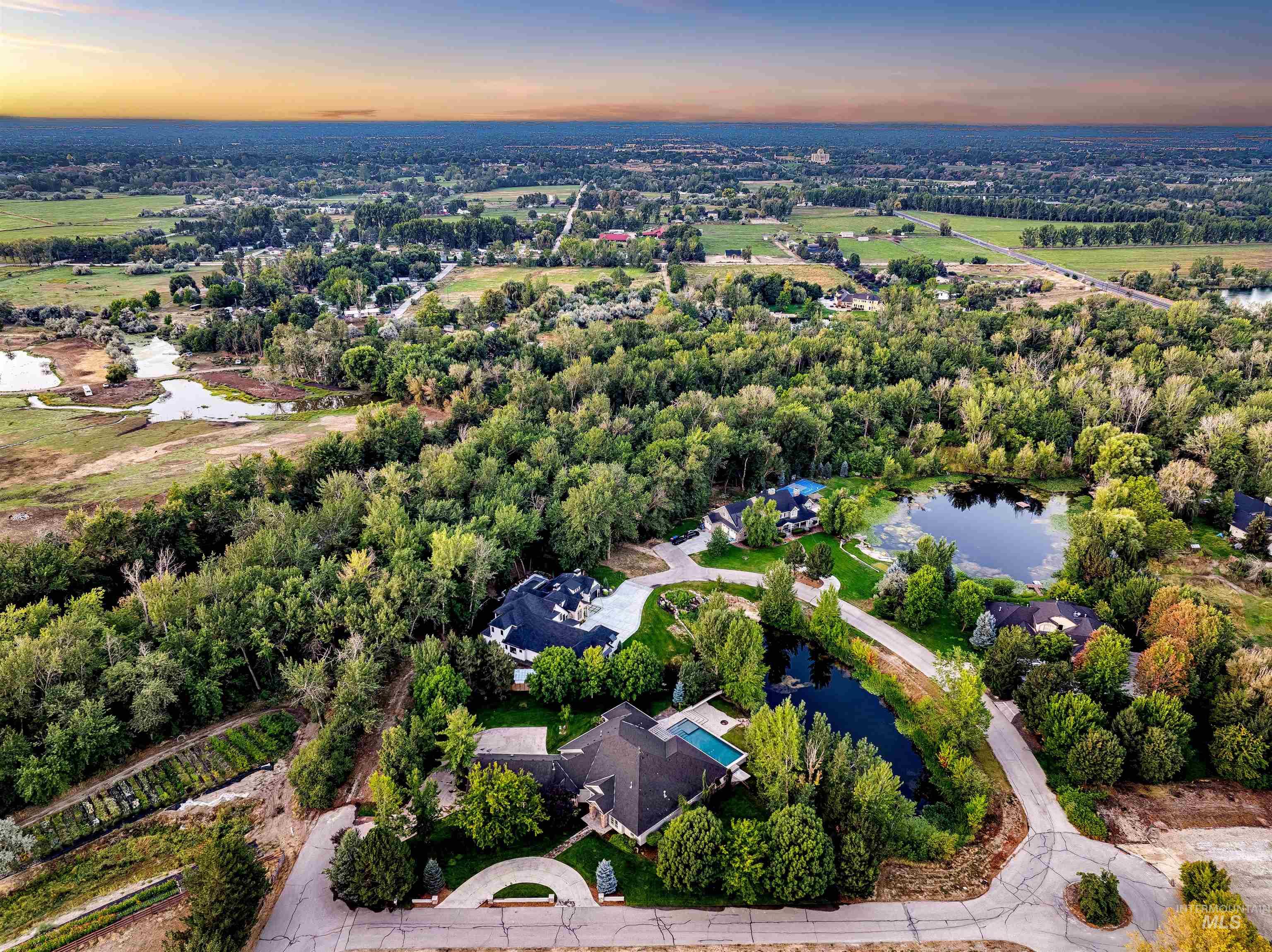 Aerial view of property's location featuring a large body of water and a tree filled landscape