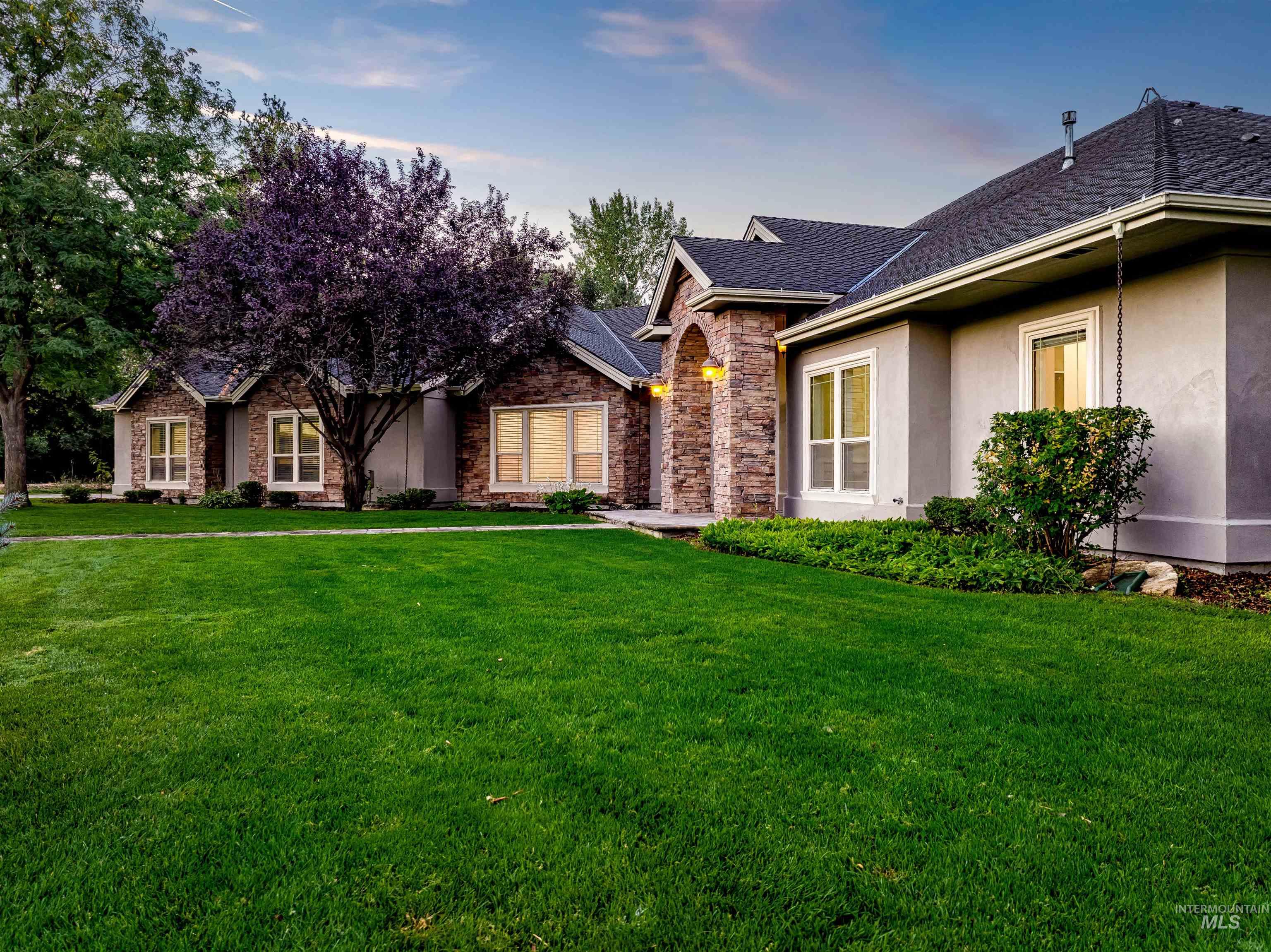 Single story home featuring stucco siding, a front yard, stone siding, and roof with shingles