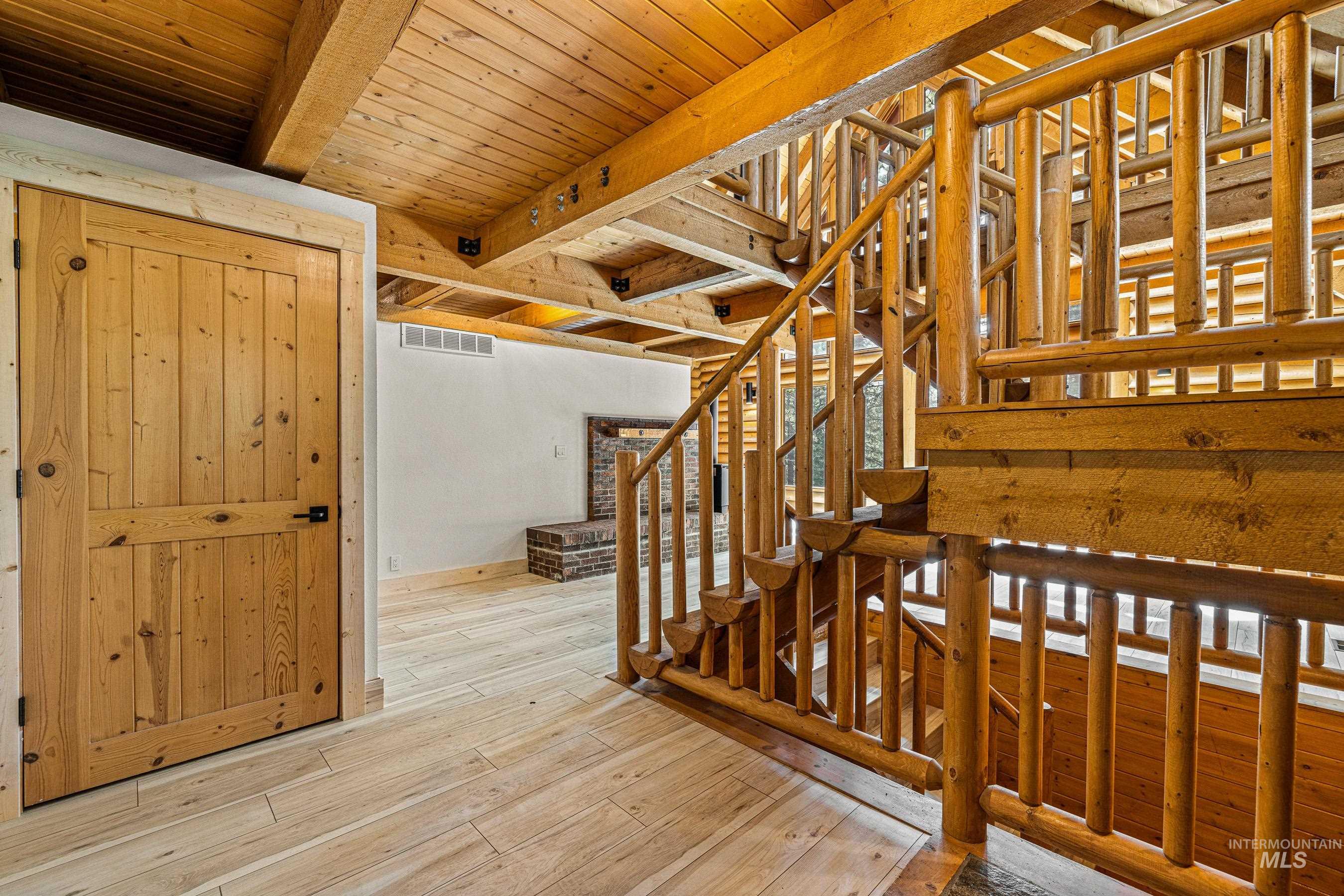 Stairway with wood finished floors and a wooden ceiling with exposed beams