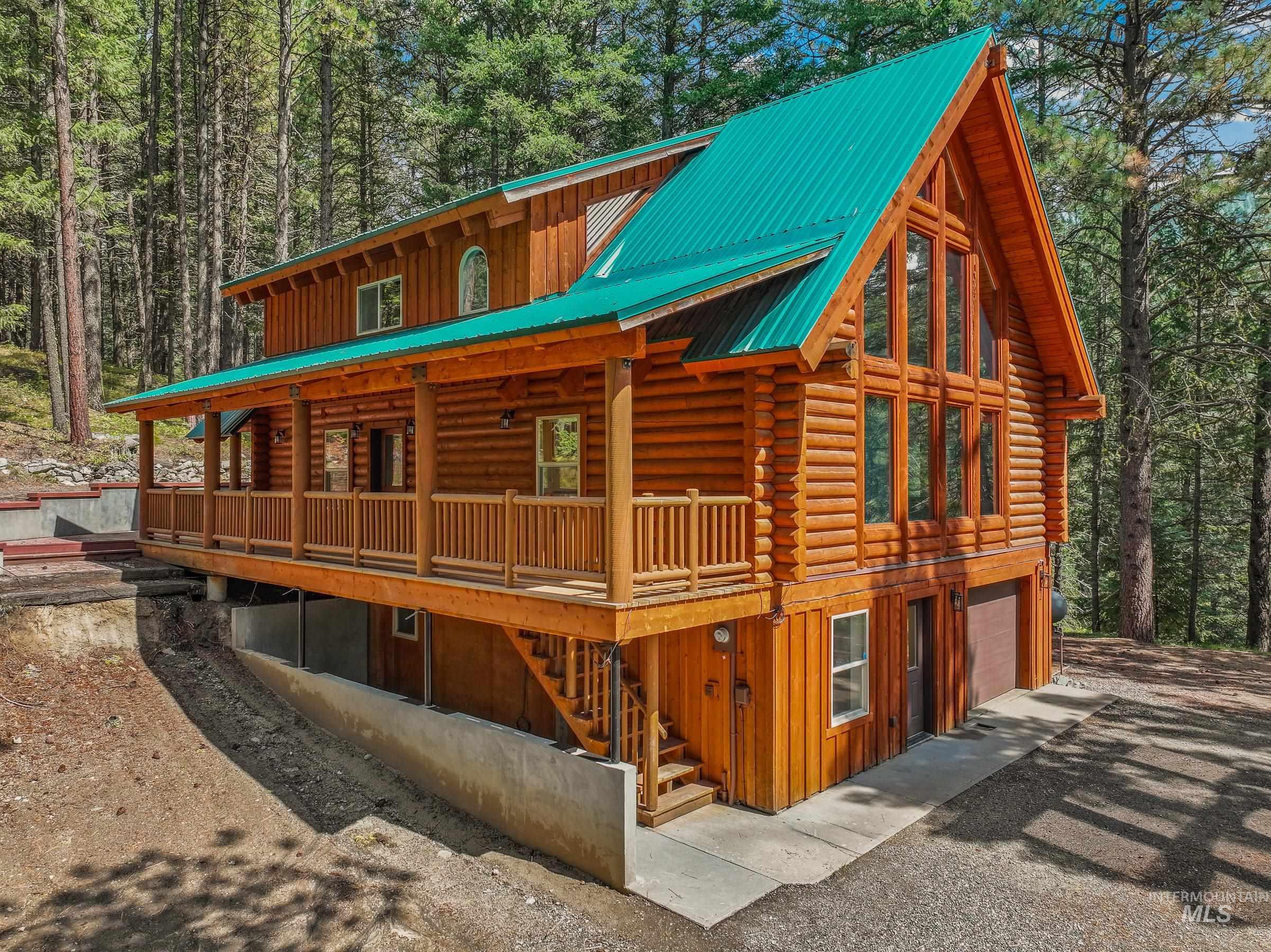 View of property exterior featuring board and batten siding, a view of trees, stairs, log siding, and a porch