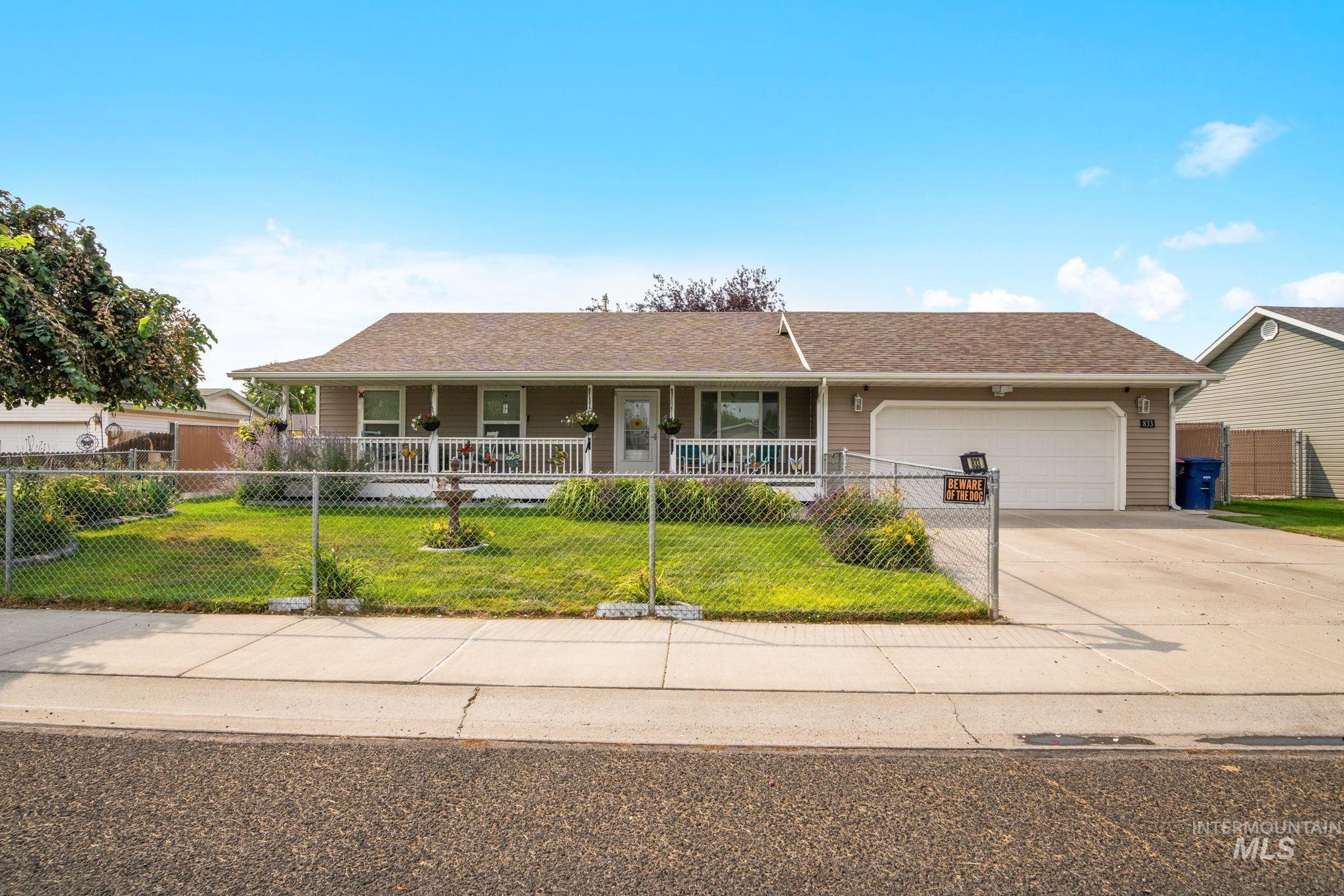 Ranch-style home with covered porch, concrete driveway, an attached garage, and a shingled roof