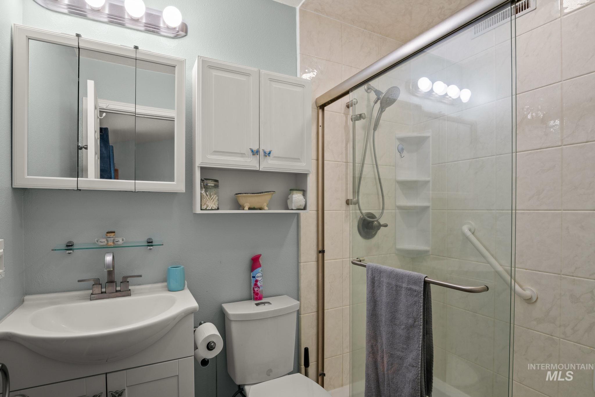 Full bathroom featuring vanity and a shower stall