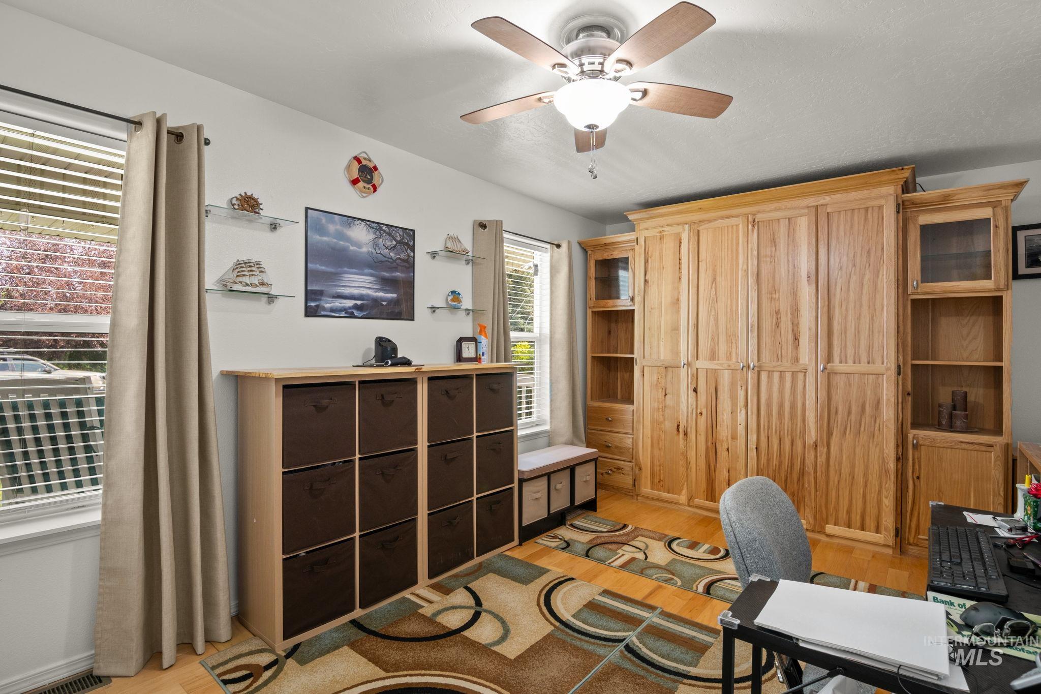 Bedroom featuring a ceiling fan and wood finished floors and Murphy Bed