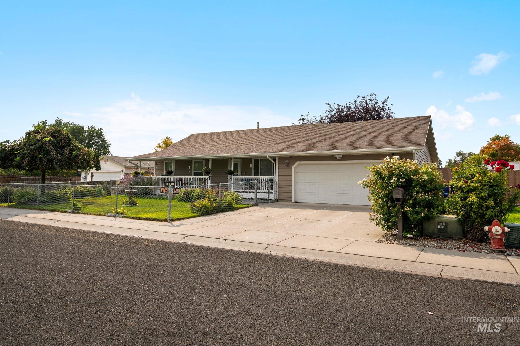 Ranch-style house with concrete driveway, roof with shingles, a garage, and covered porch