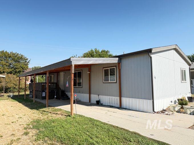 View of front facade with a front yard and a carport