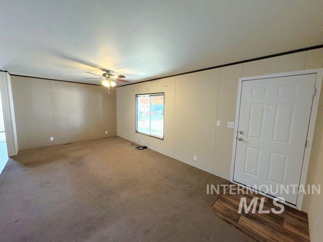 Carpeted entrance foyer featuring a ceiling fan