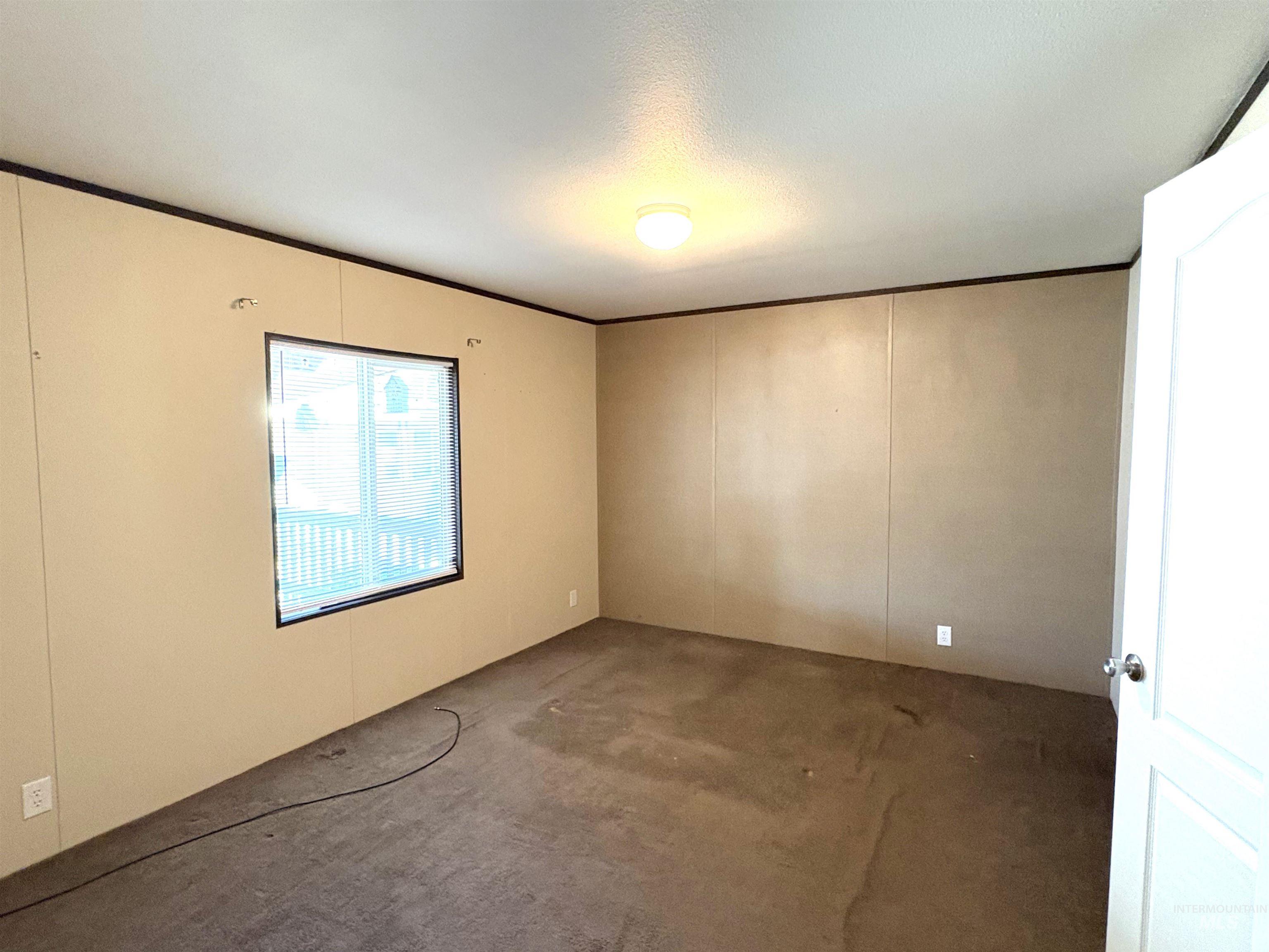 Unfurnished room with carpet, ornamental molding, and a decorative wall