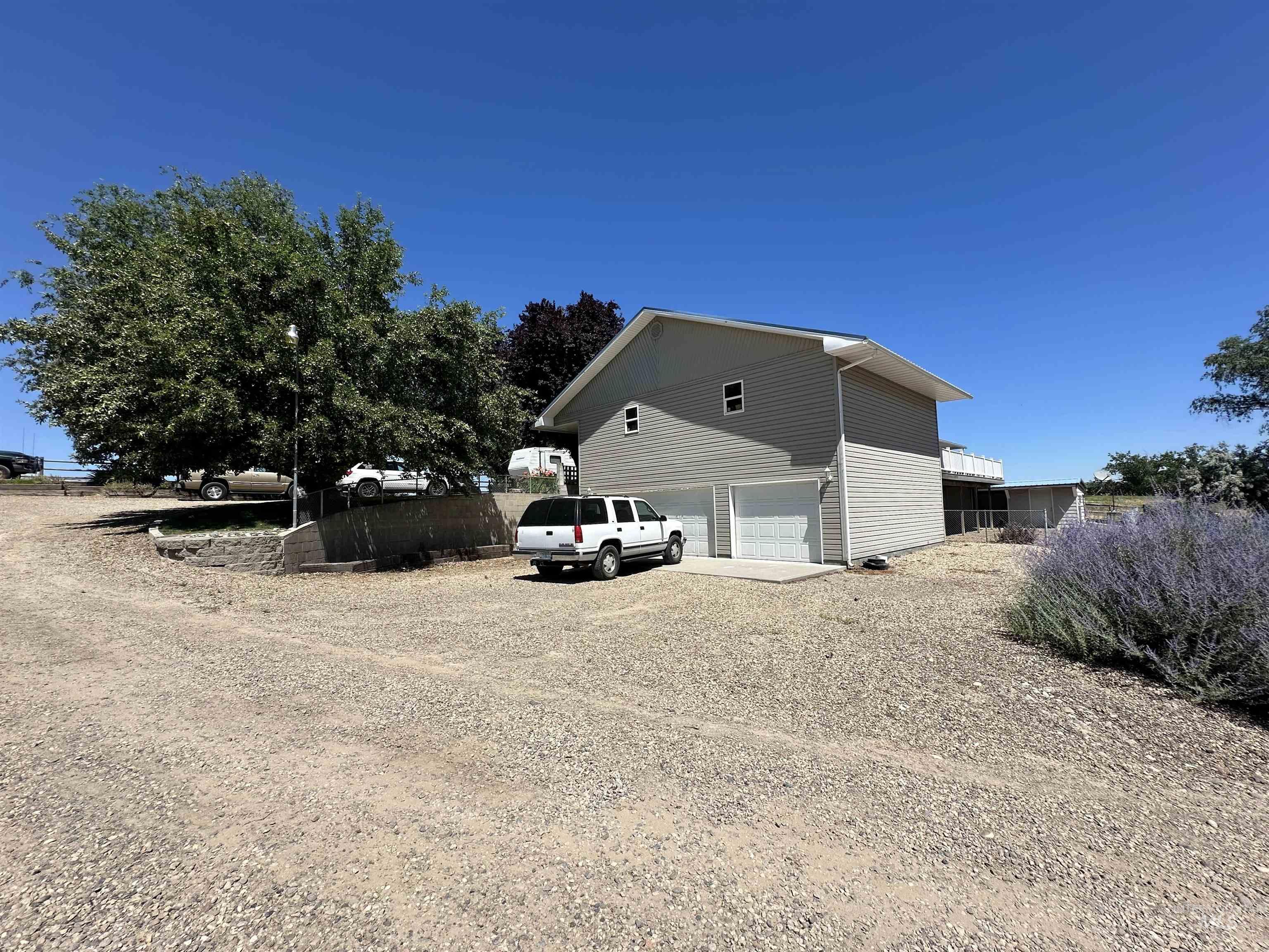 View of side of property featuring an attached garage and dirt driveway