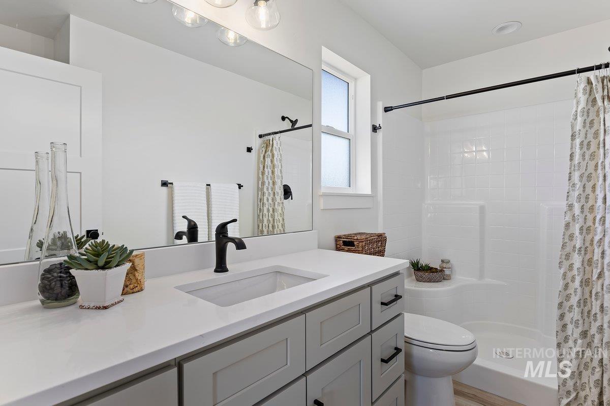 Full bathroom with vanity and a shower stall