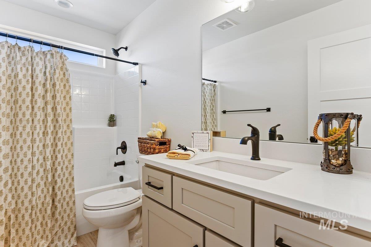 Full bathroom with shower / tub combo with curtain and vanity