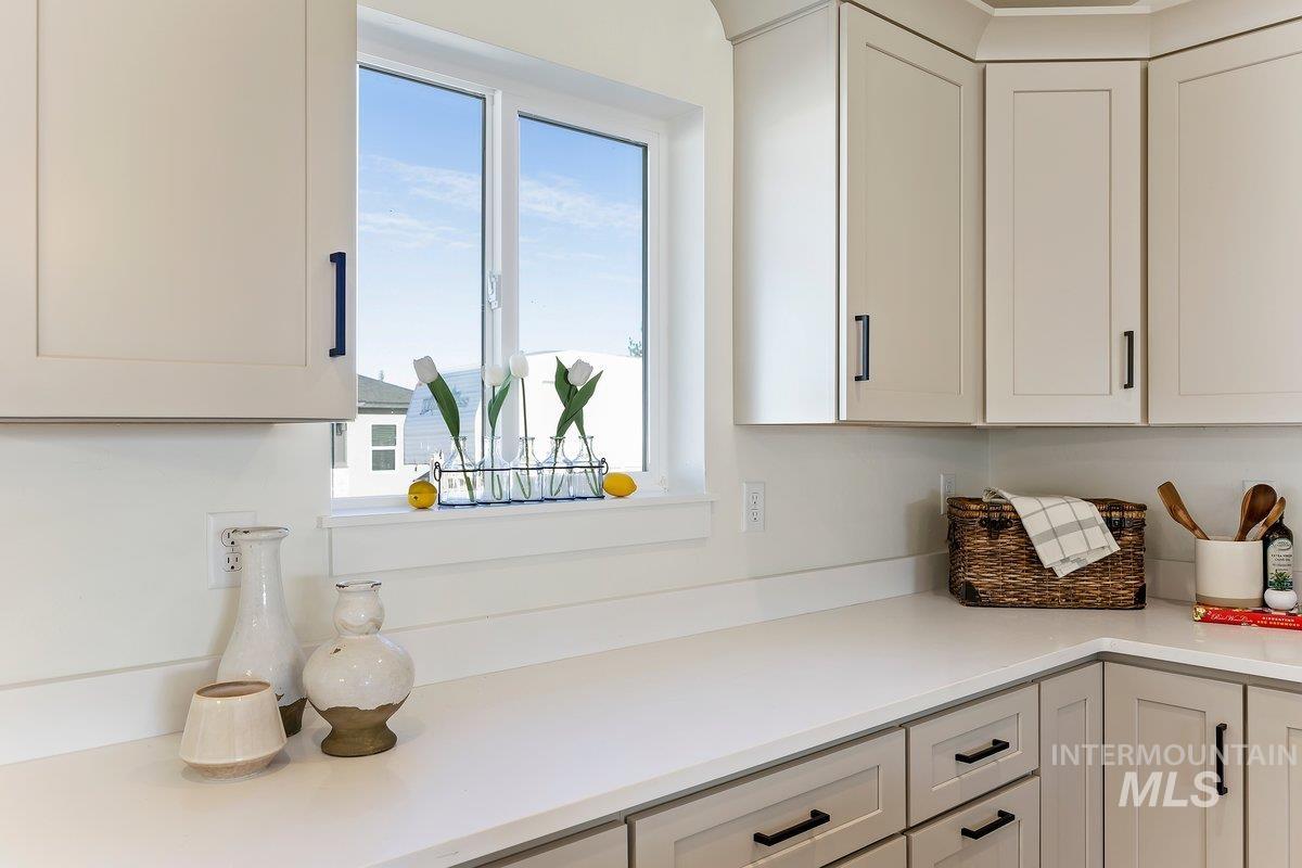 Kitchen with white cabinets and light stone countertops