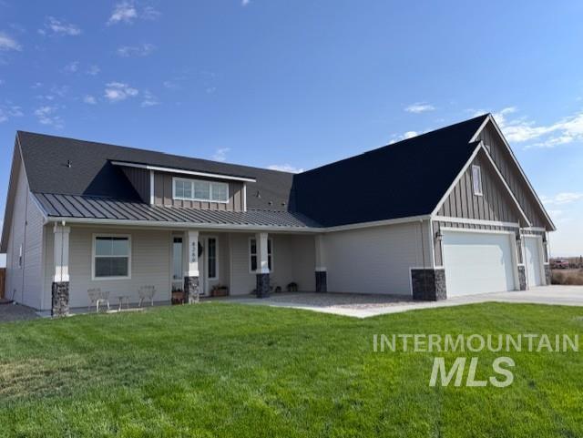 View of front of house with board and batten siding, a metal roof, a standing seam roof, and a front yard