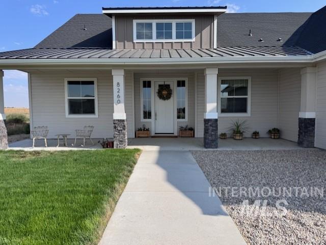 Property entrance featuring a porch, a standing seam roof, and a metal roof