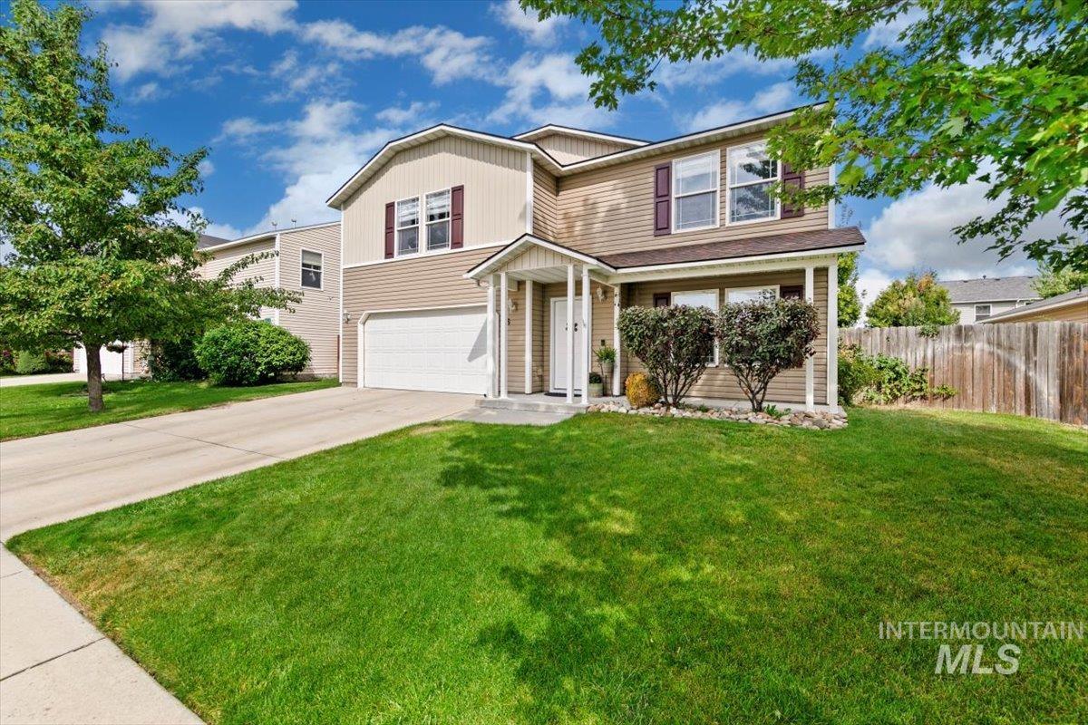 View of front of property with driveway and an attached garage