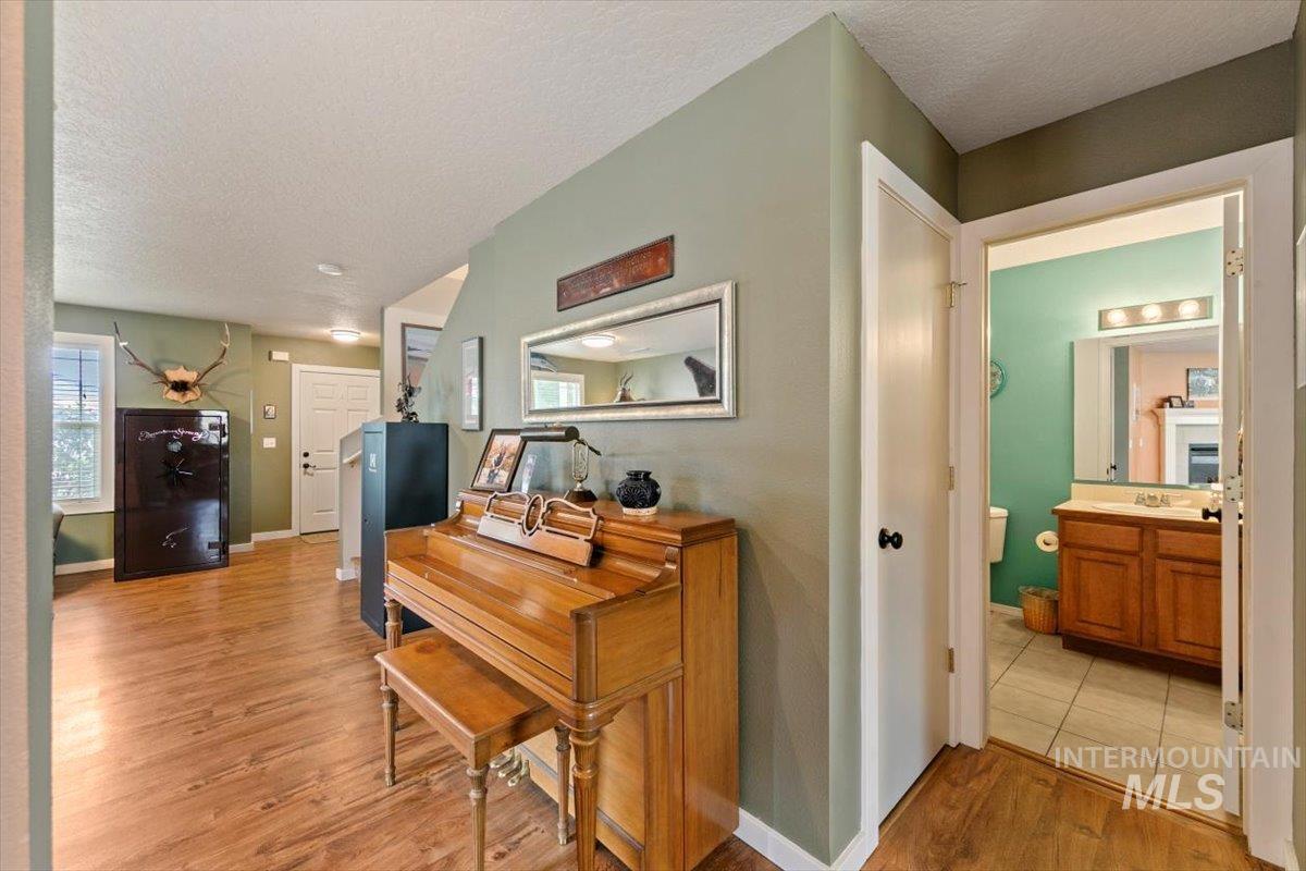 Hallway featuring light wood-style flooring and a textured ceiling