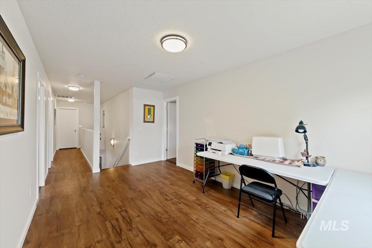 Home office with dark wood finished floors and baseboards