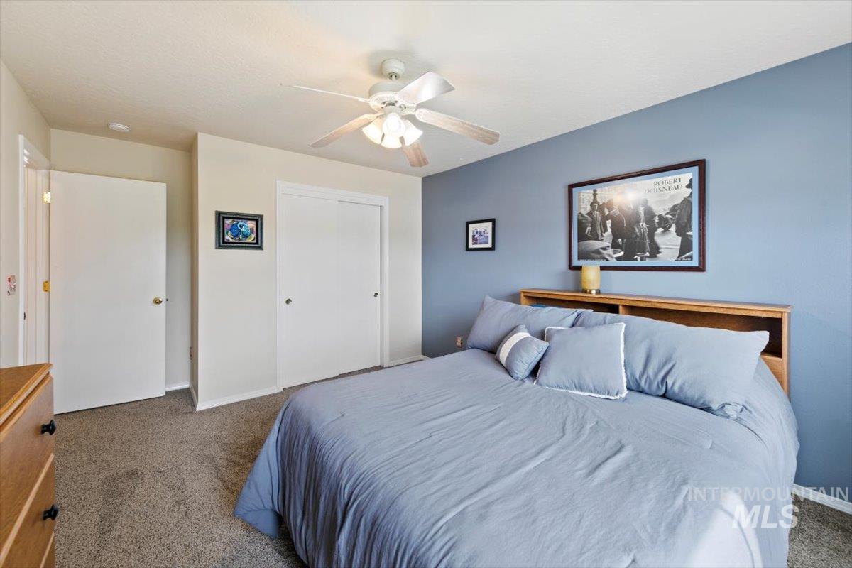 Carpeted bedroom featuring a closet and a ceiling fan