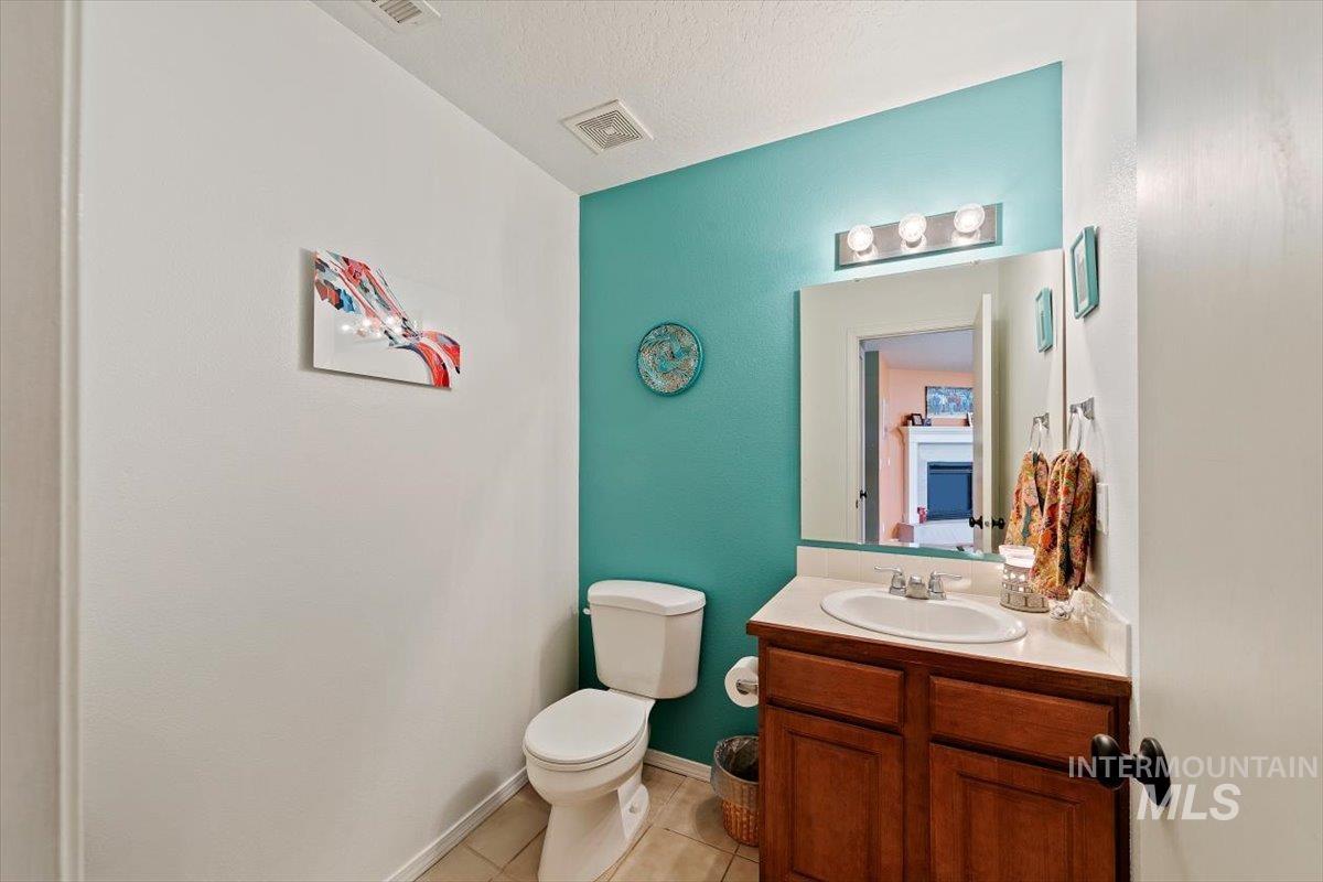 Bathroom featuring light tile patterned floors, vanity, and a textured ceiling