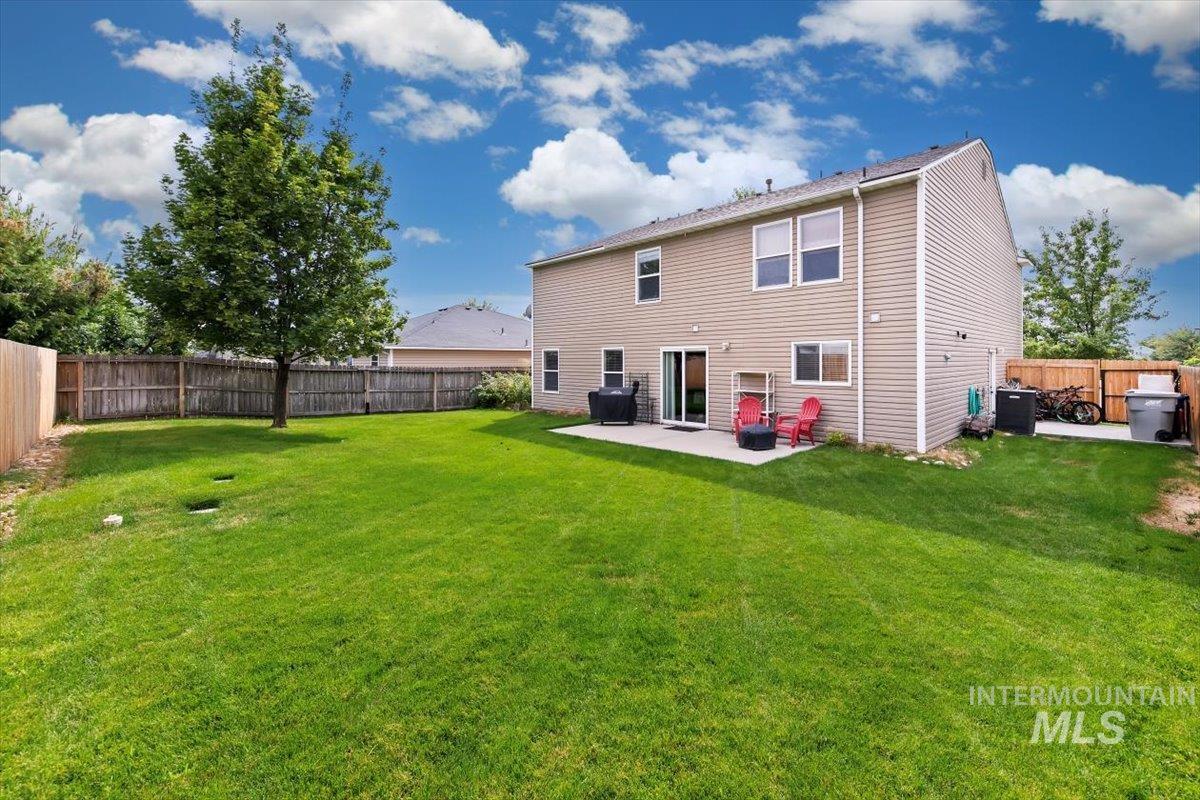Back of property featuring a fenced backyard and a patio