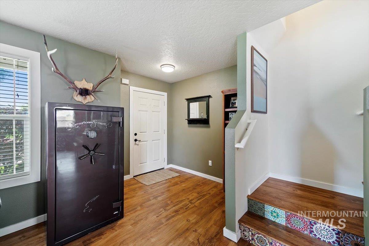 Foyer entrance featuring a textured ceiling and wood finished floors