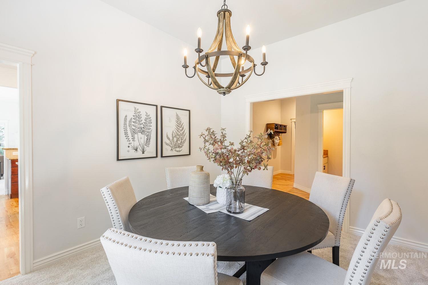 Dining space with a chandelier and light colored carpet