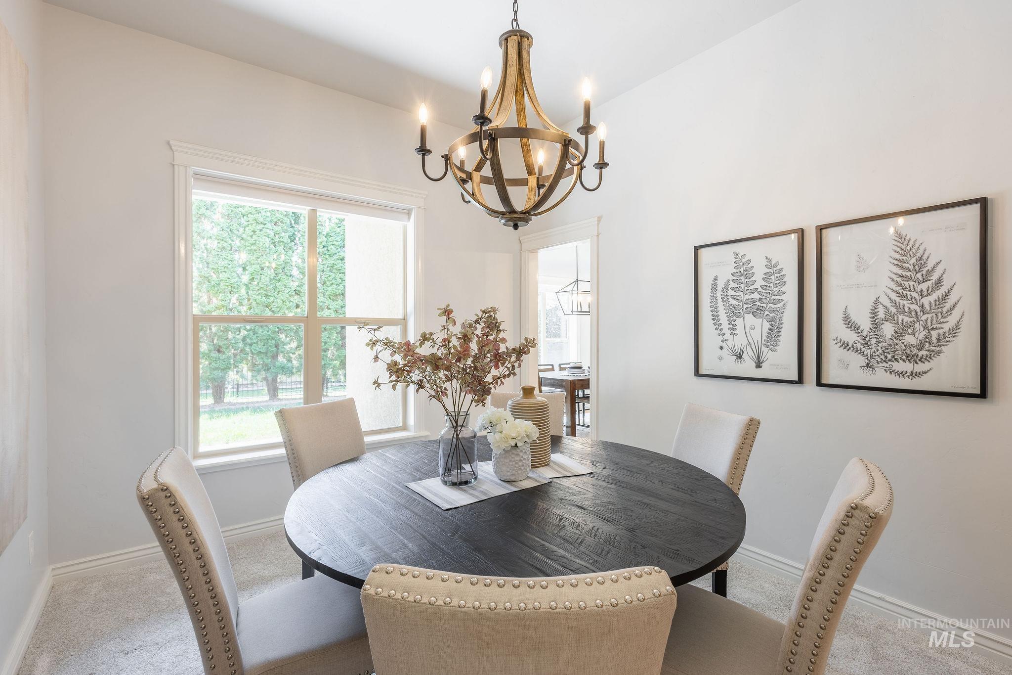 Carpeted dining room with baseboards and a chandelier