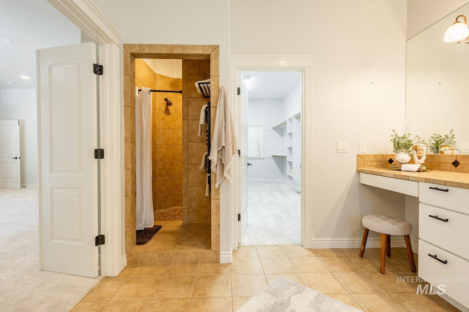 Full bathroom with a shower stall, vanity, and light tile patterned floors