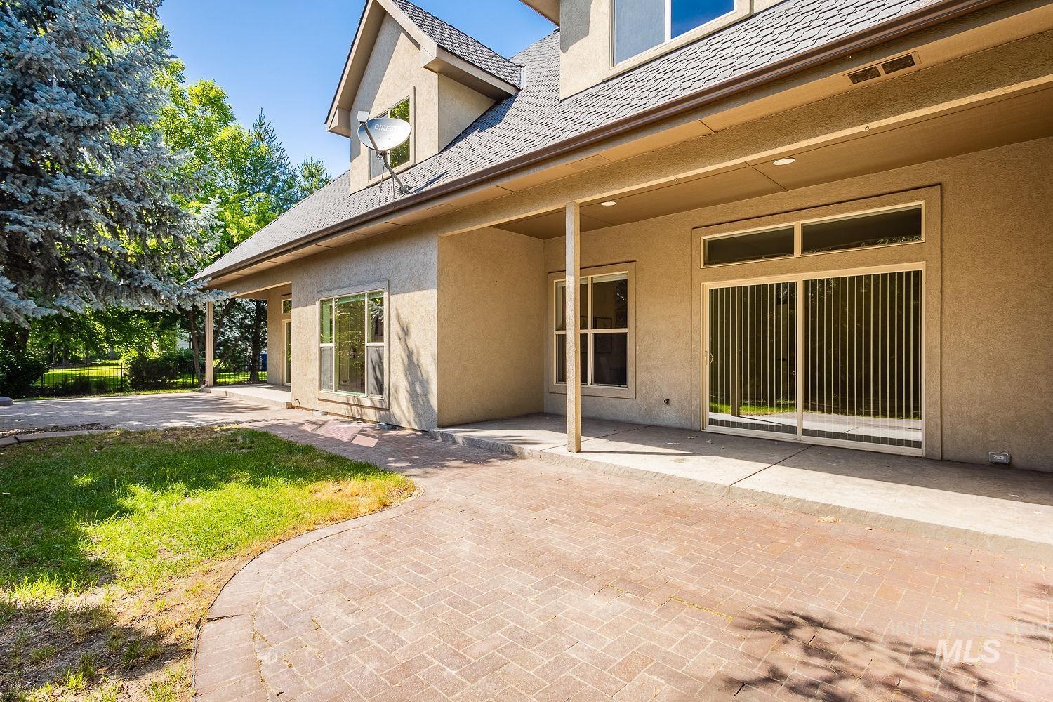 Back of property with a patio area, stucco siding, and a yard