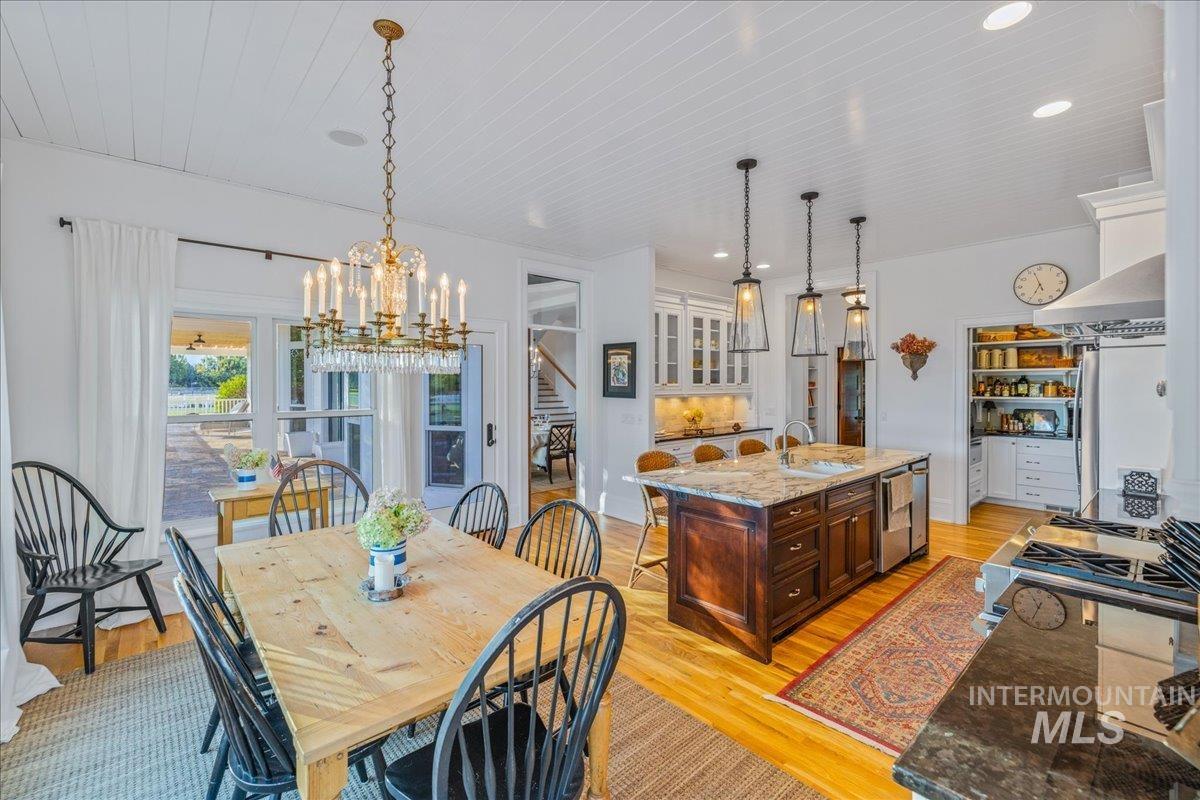 Dining space with light wood-style floors, recessed lighting, stairs, a chandelier, and wood ceiling