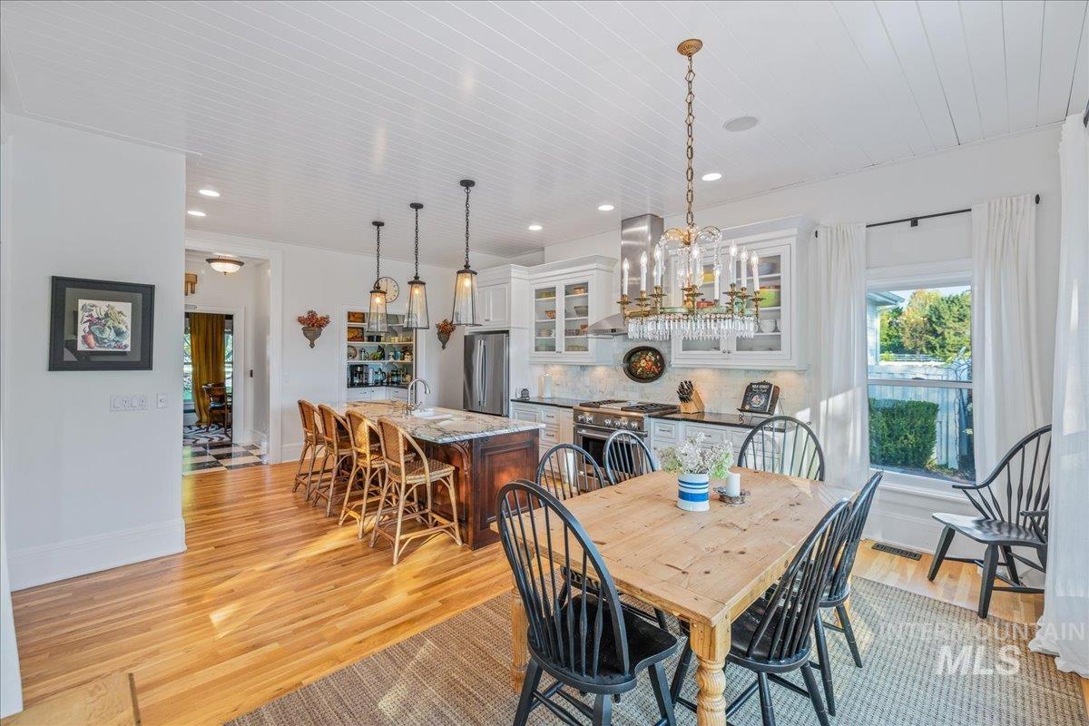 Dining room with light wood-type flooring and recessed lighting