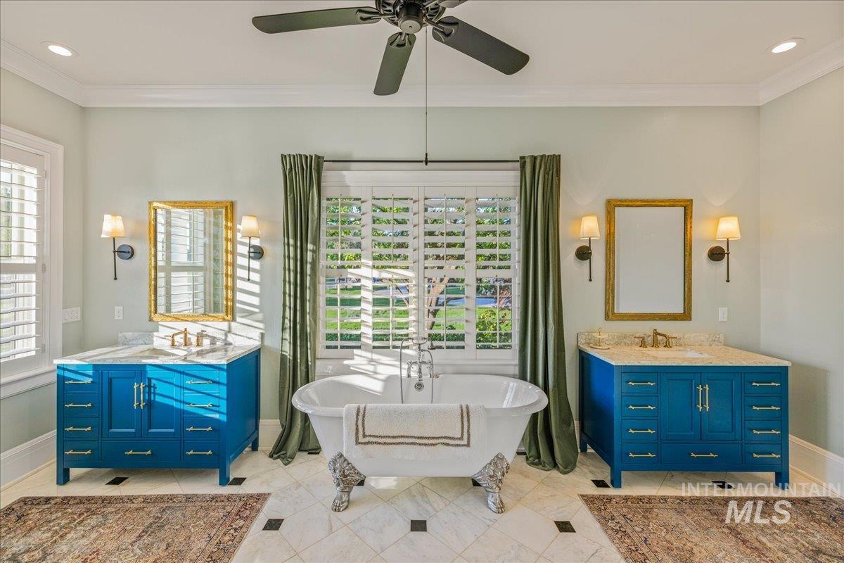 Full bath with crown molding, recessed lighting, two vanities, a soaking tub, and ceiling fan