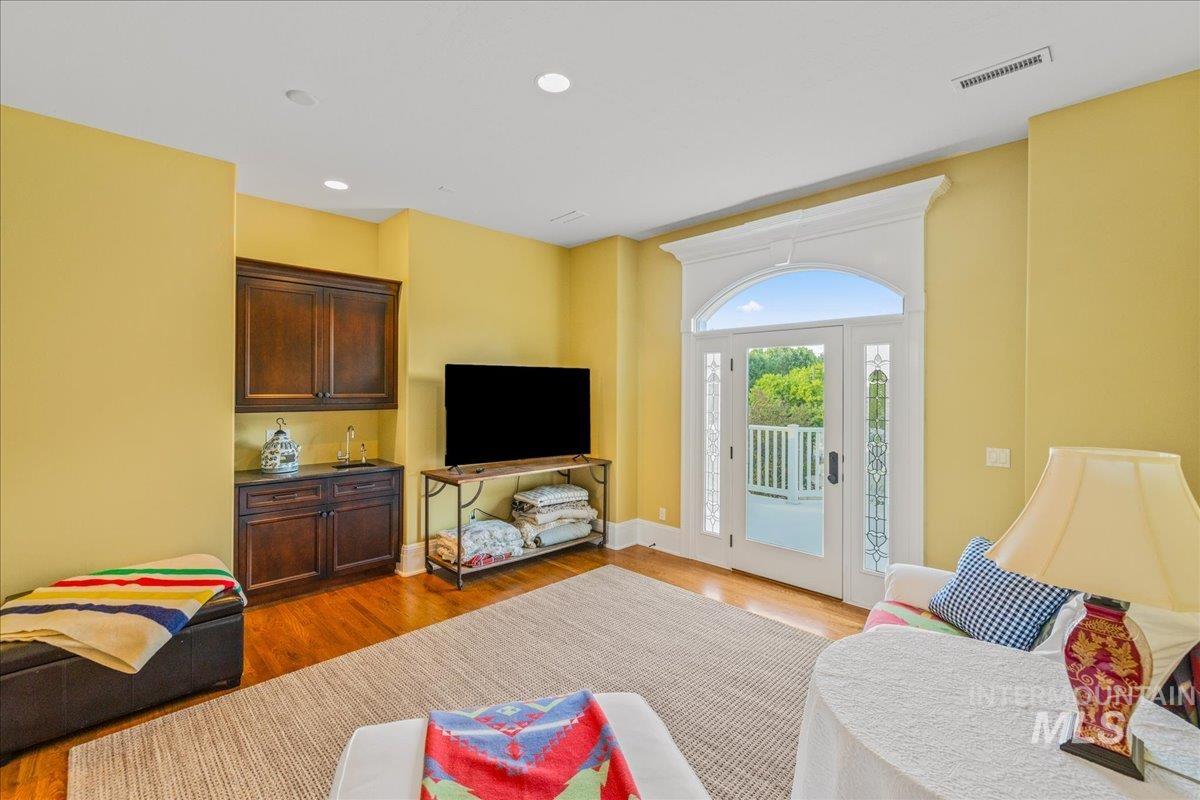 Living room with light wood-type flooring and recessed lighting