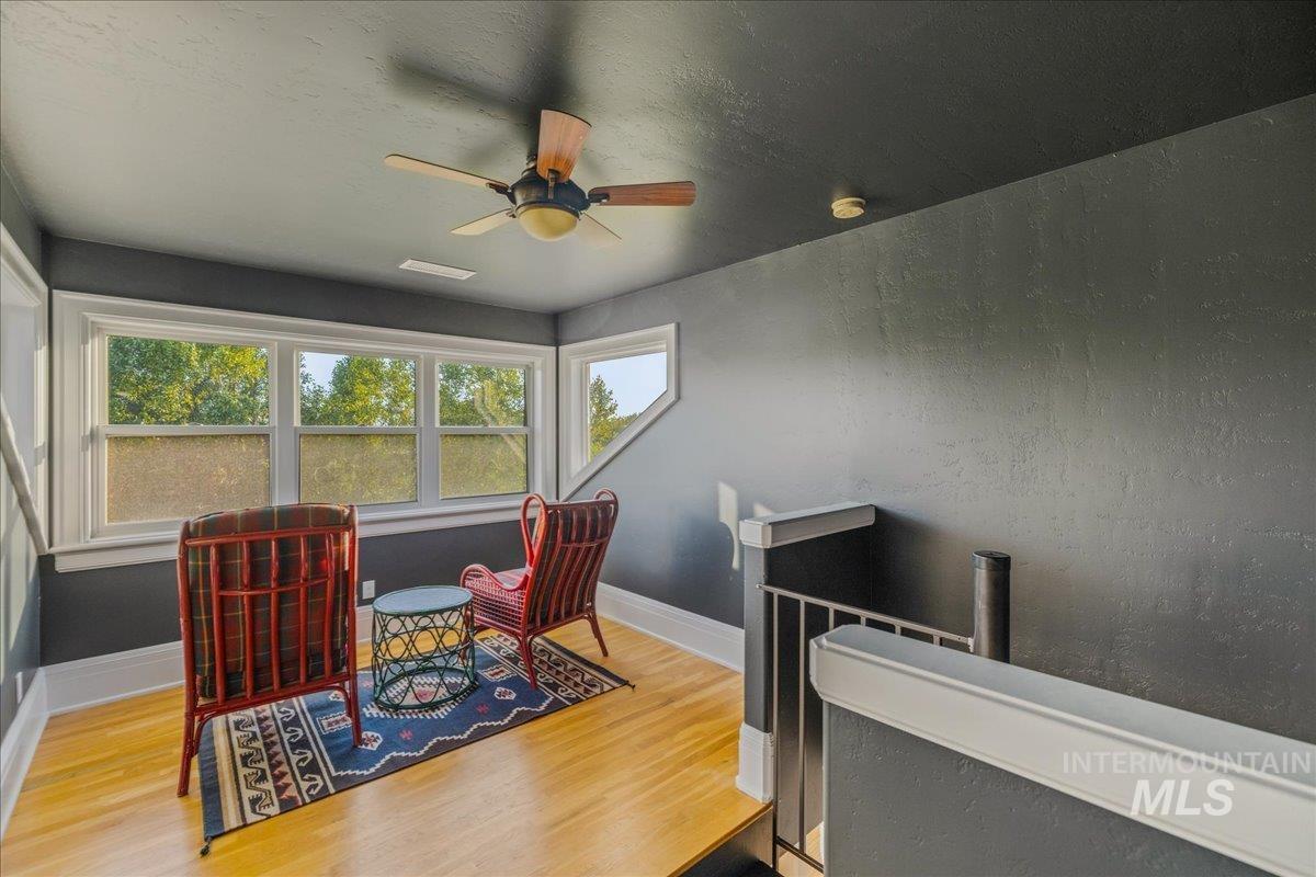 Office space featuring wood finished floors, a ceiling fan, a textured ceiling, and a textured wall